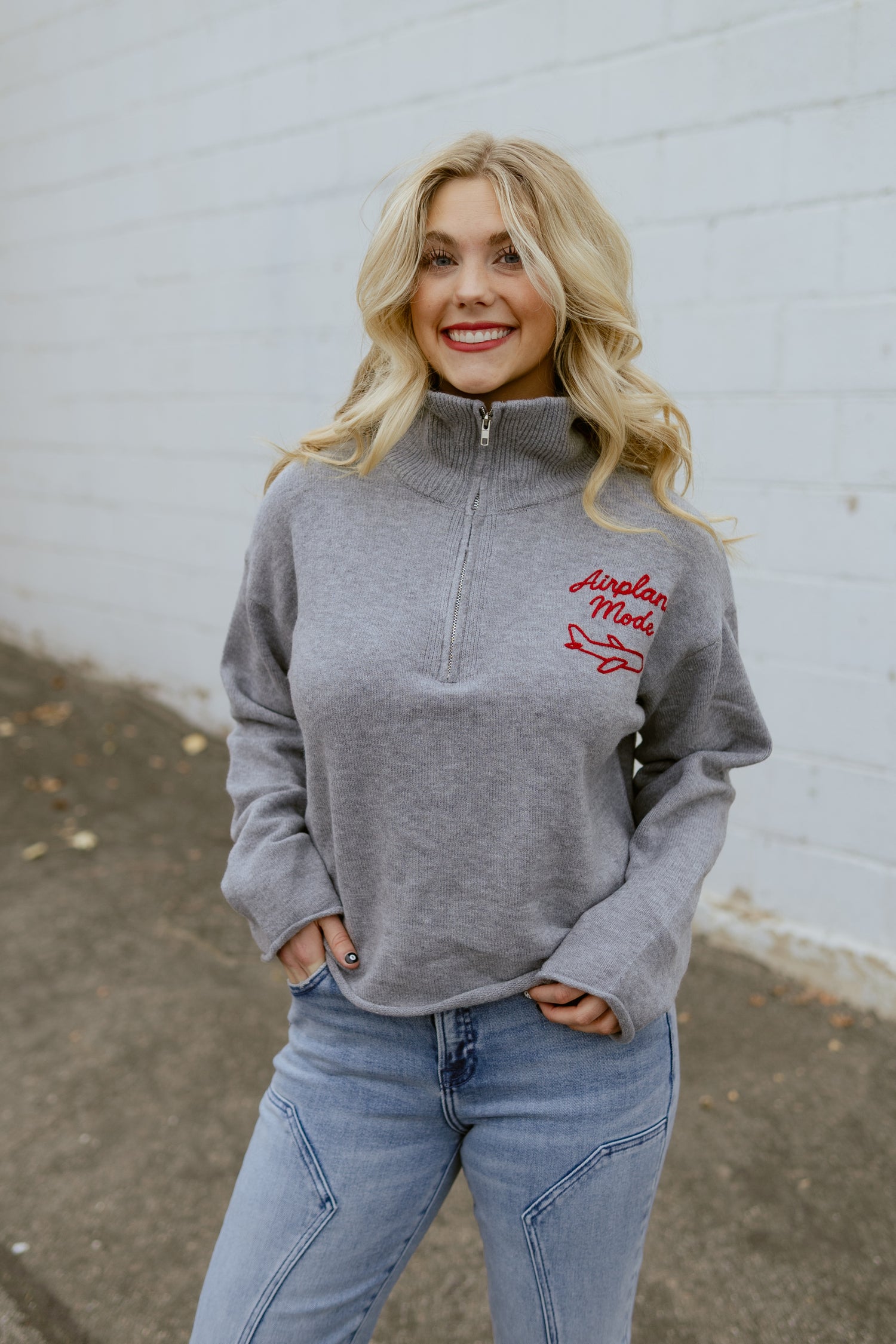 Grey sweater with Airplane Mode embroidered on the corner in red