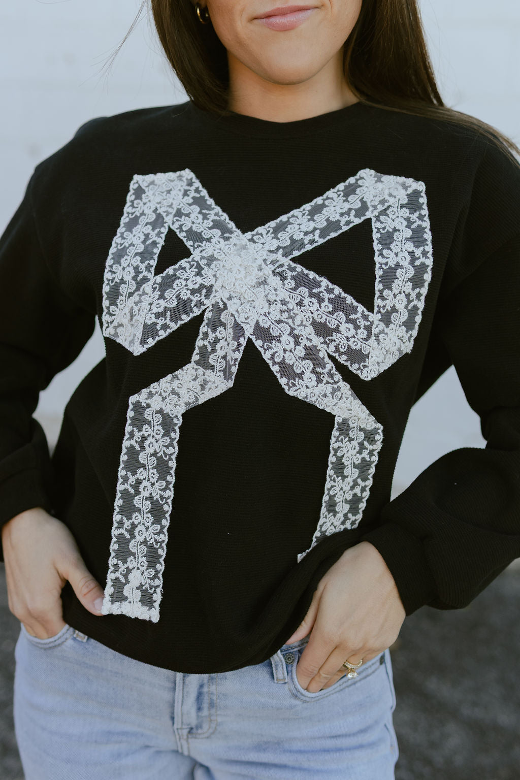 black sweatshirt with white lace bow on the front