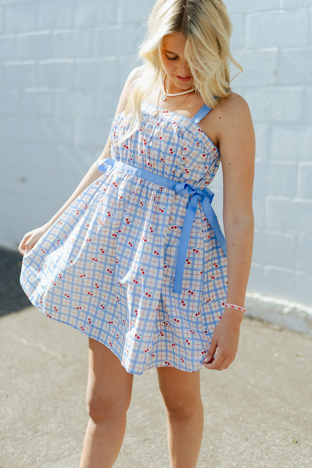 Blue and red plaid mini dress with blue ribbon around the waist