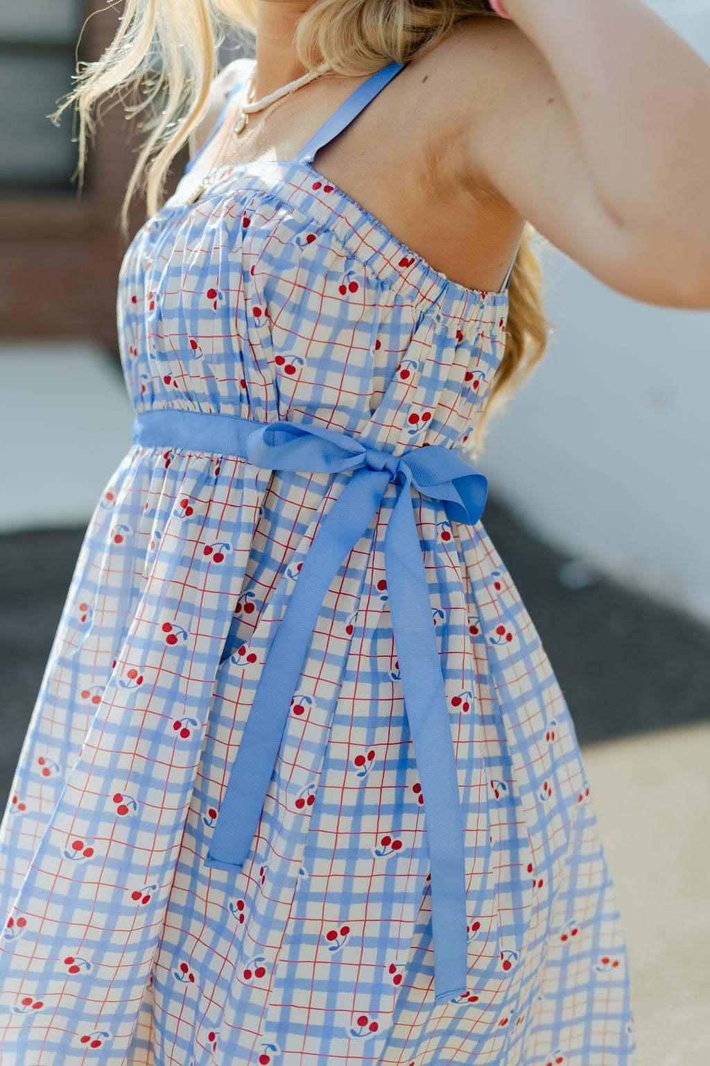 Blue and red plaid mini dress with blue ribbon around the waist