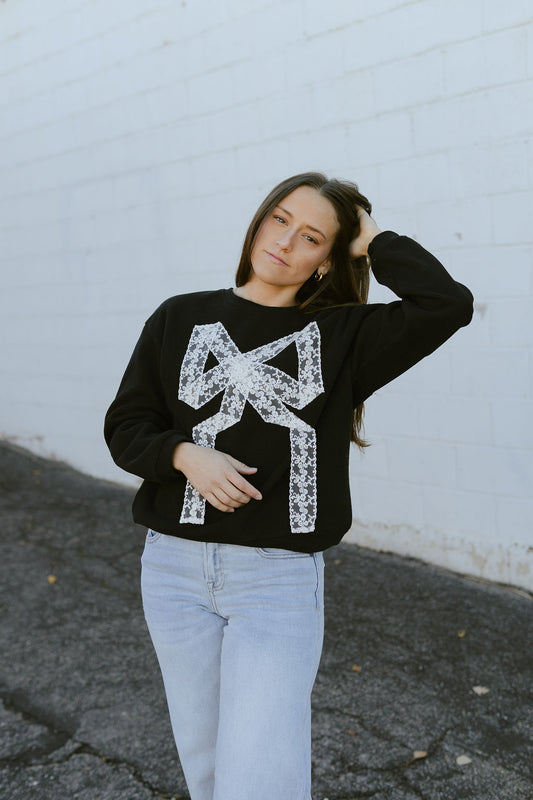 black sweatshirt with white lace bow on the front