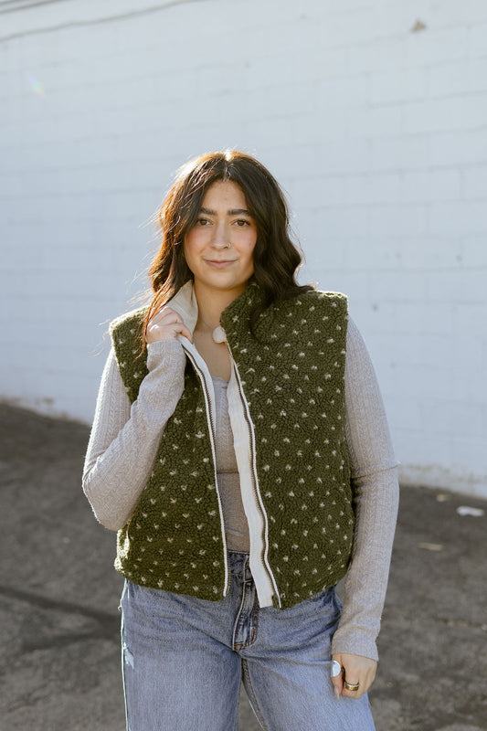 Olive green shearling vest with tiny white flowers and a zipper up the front
