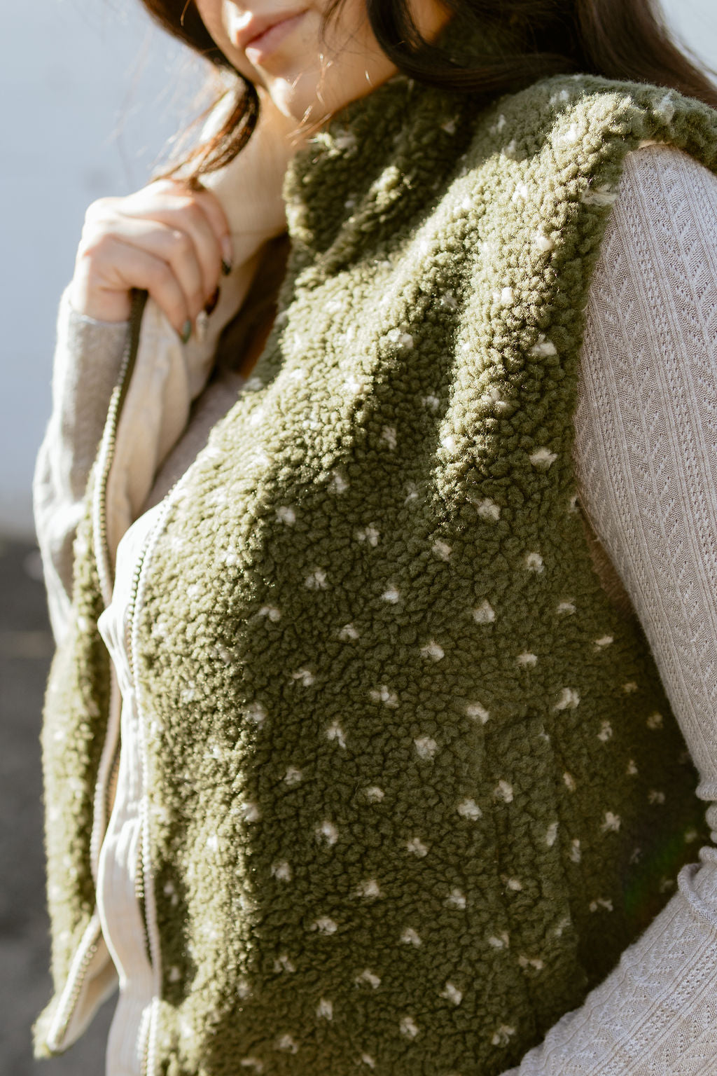 Olive green shearling vest with tiny white flowers and a zipper up the front