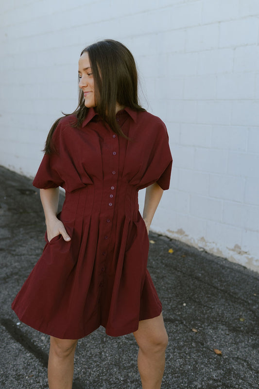 Dark red dress with knife pleats along the front and buttons up the front