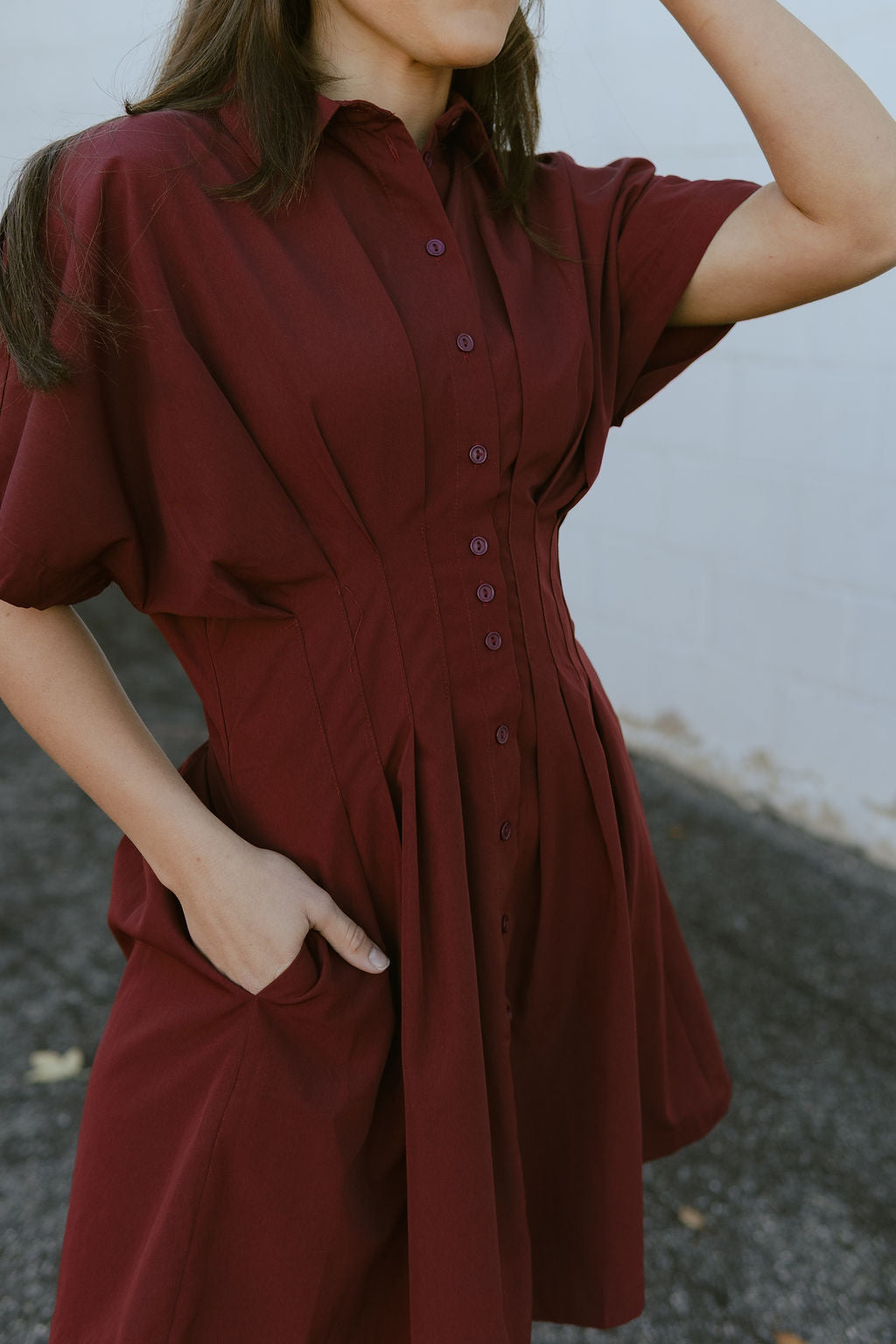 Dark red dress with knife pleats along the front and buttons up the front