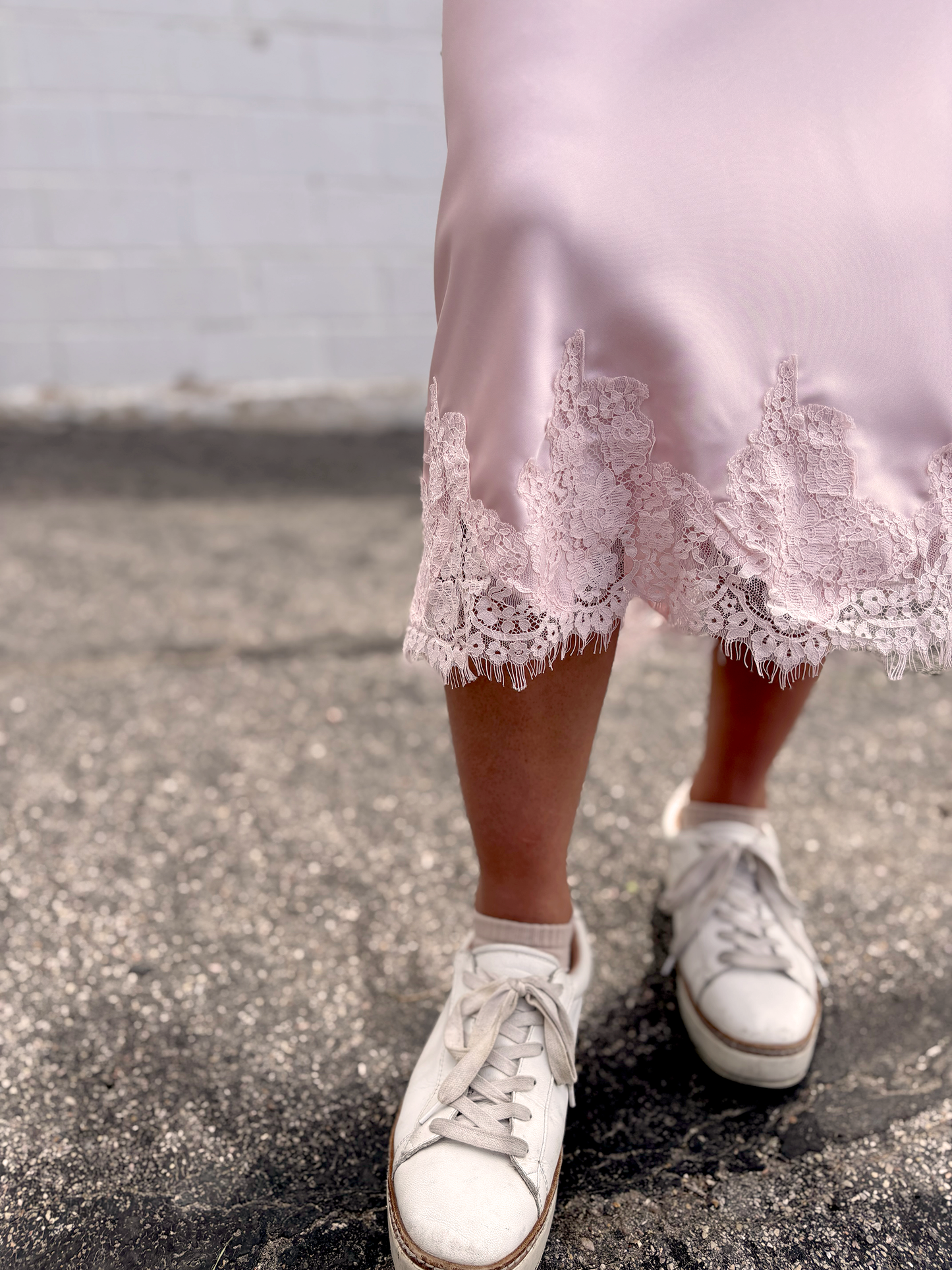 Pink satin skirt with lace trim along the bottom