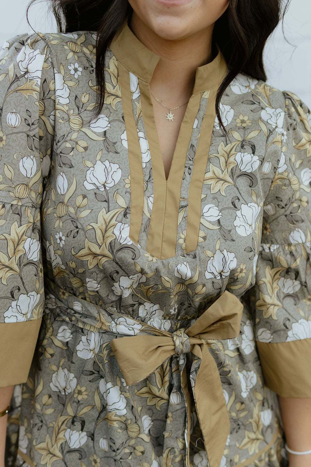 Neutral floral dress with tan accents and bow tie belt
