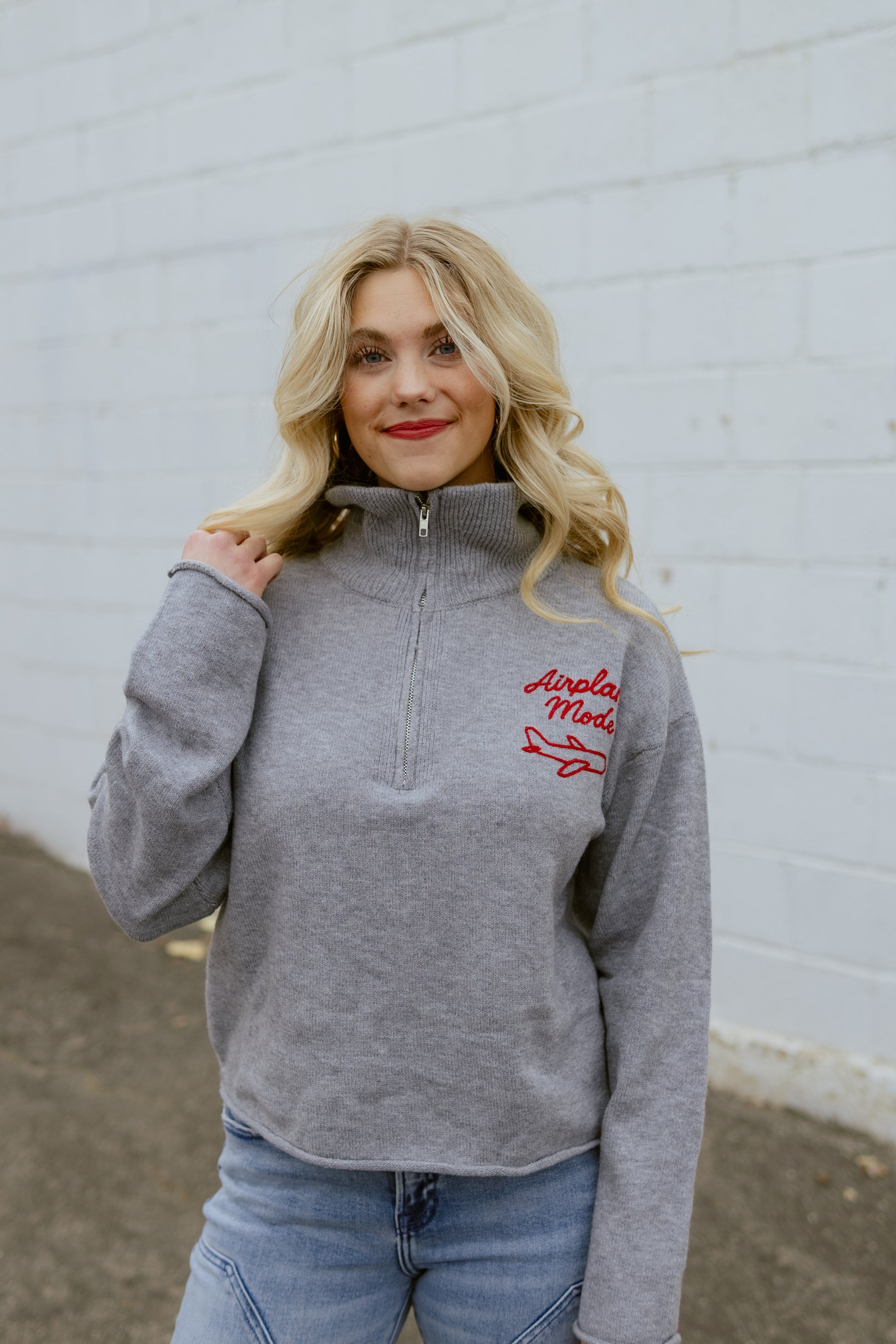 Grey sweater with Airplane Mode embroidered on the corner in red