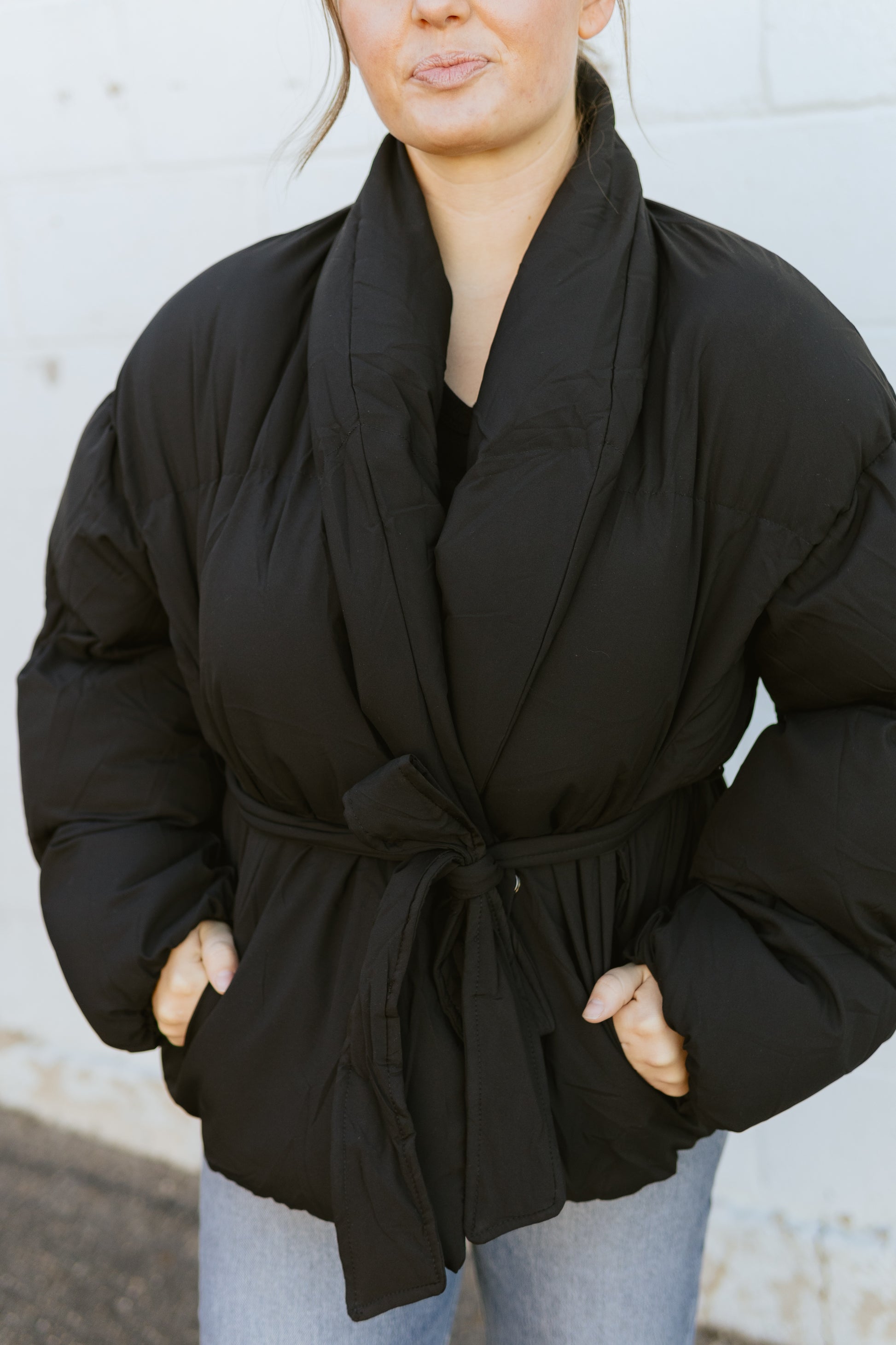 Black fitted puffer jacket with tie at the waist