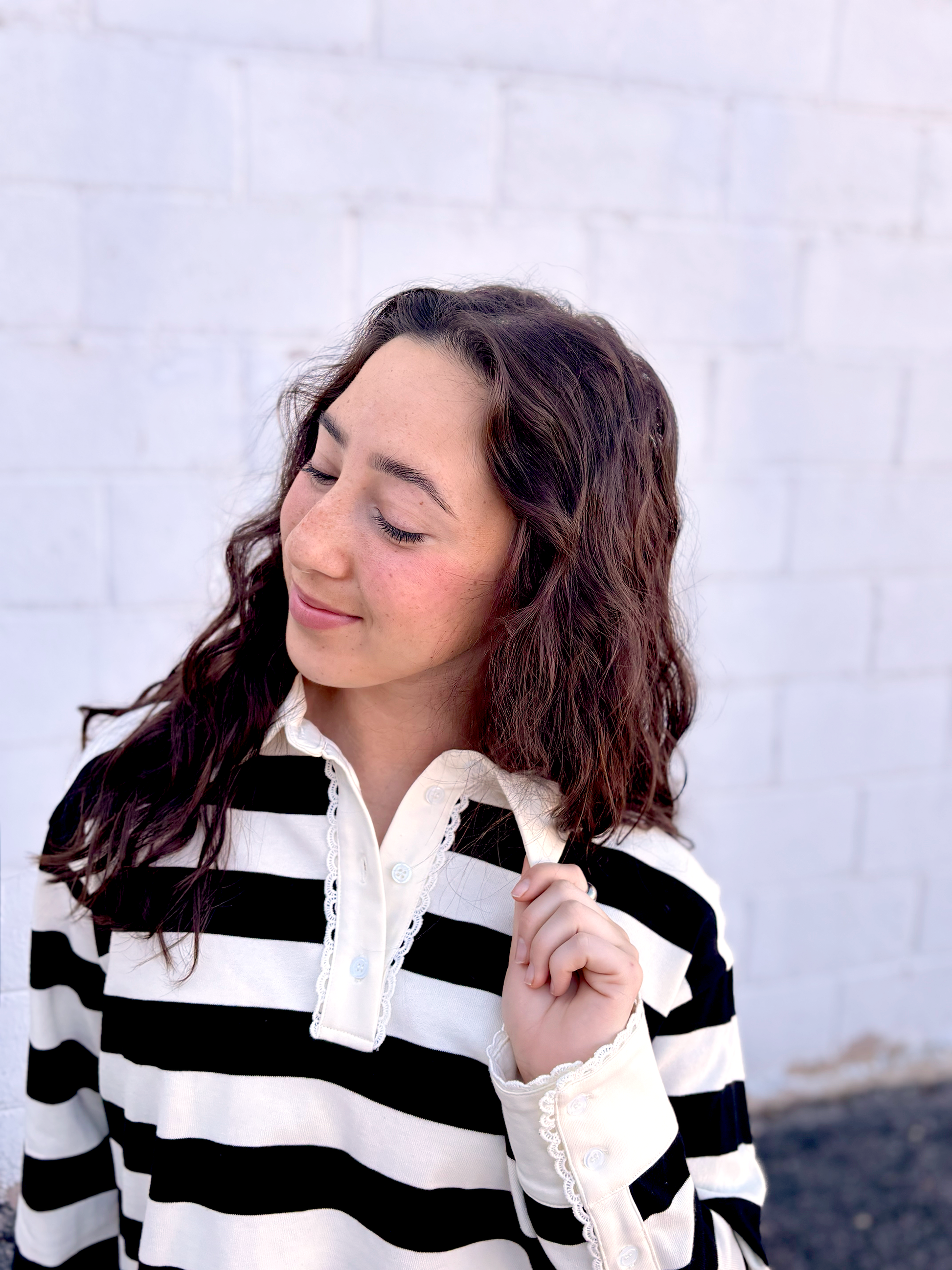 black and white striped top with long sleeves and delicate lace details around the neckline and cuffs