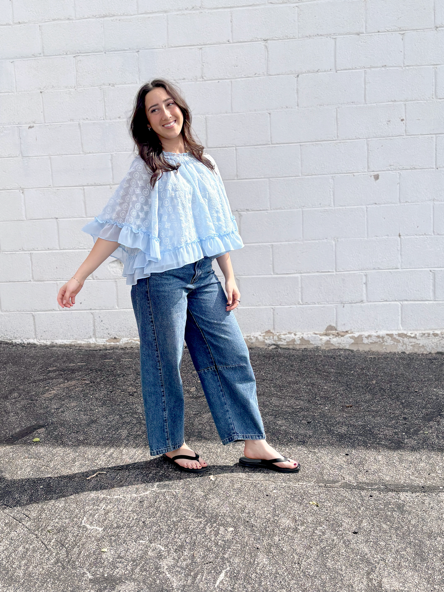 Light blue cape top with white embroidered pattern over top and ruffles along the sleeves and bottom of top