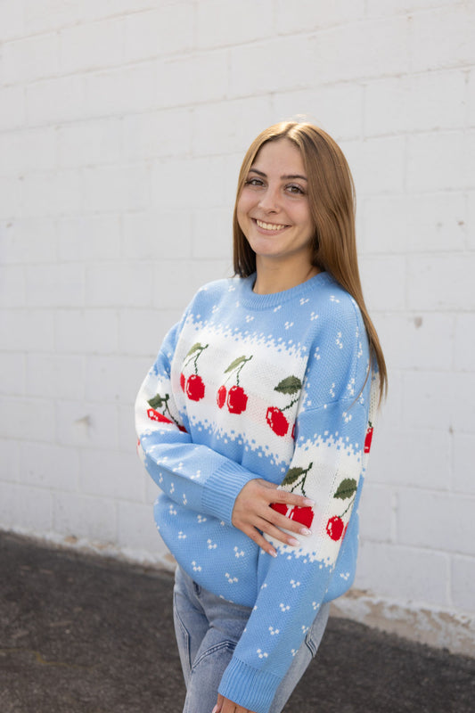 Blue knit sweater with cherry pattern