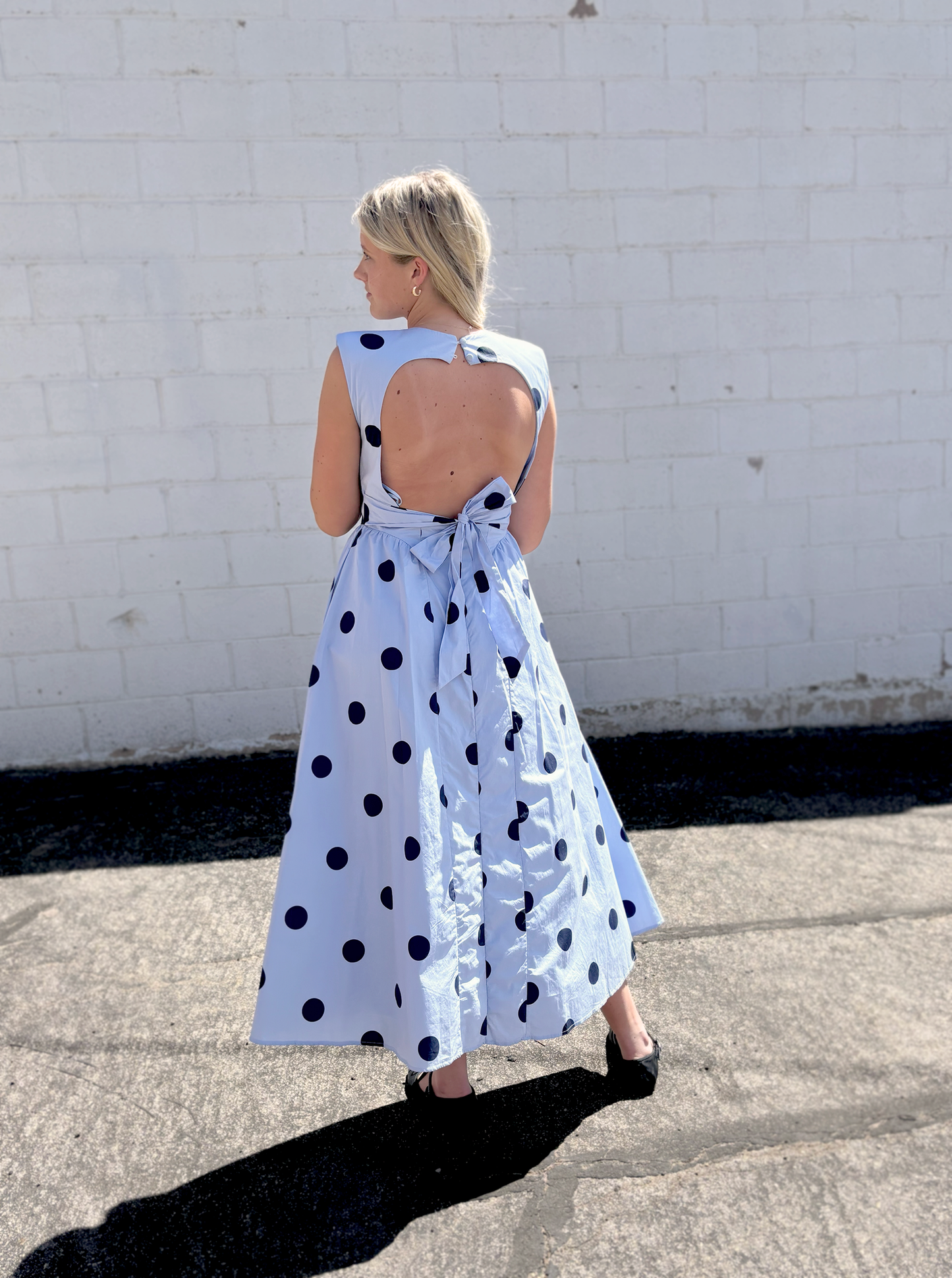 light blue sleeveless dress with navy polka dots and backless