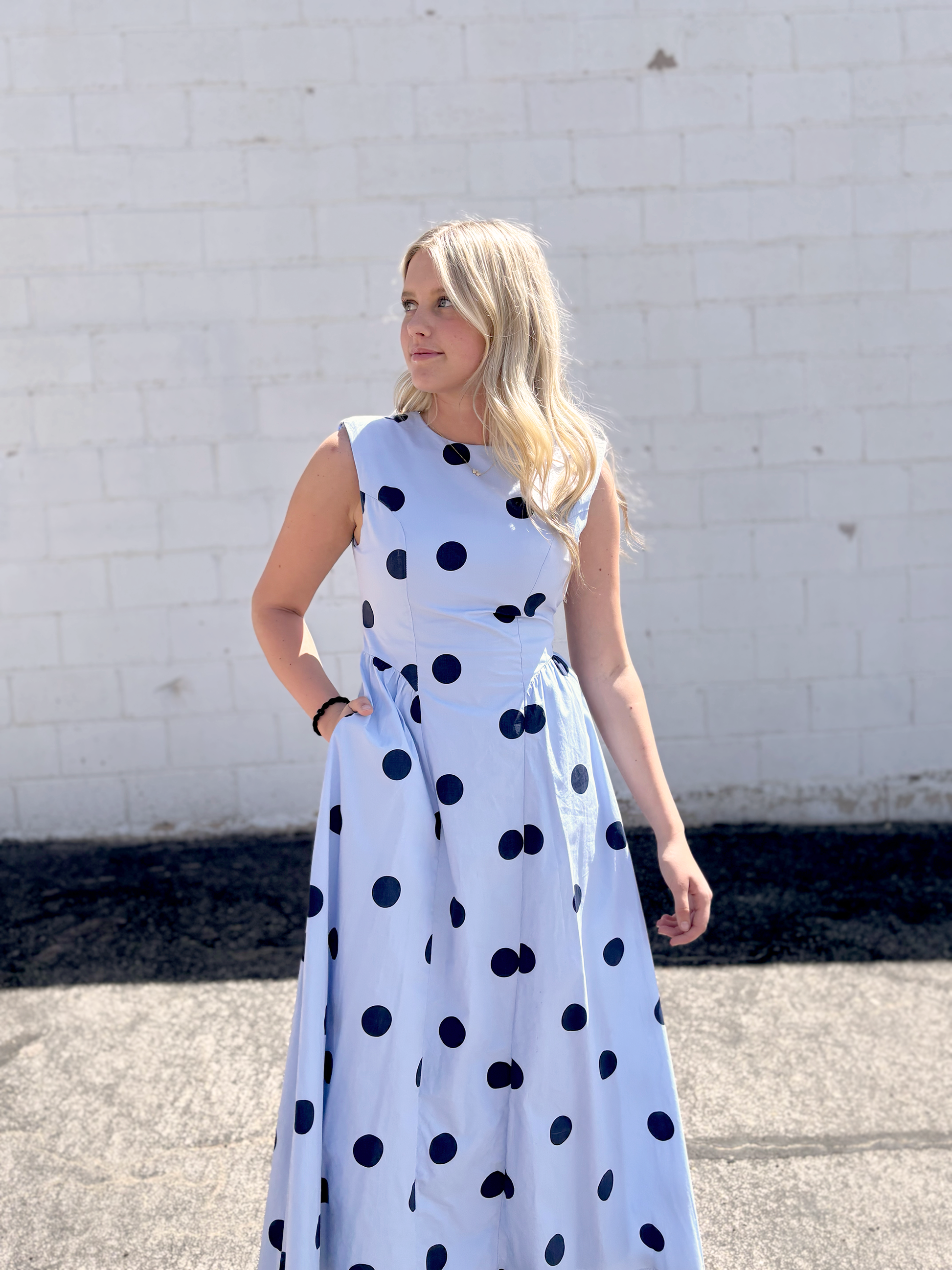 light blue sleeveless dress with navy polka dots and backless