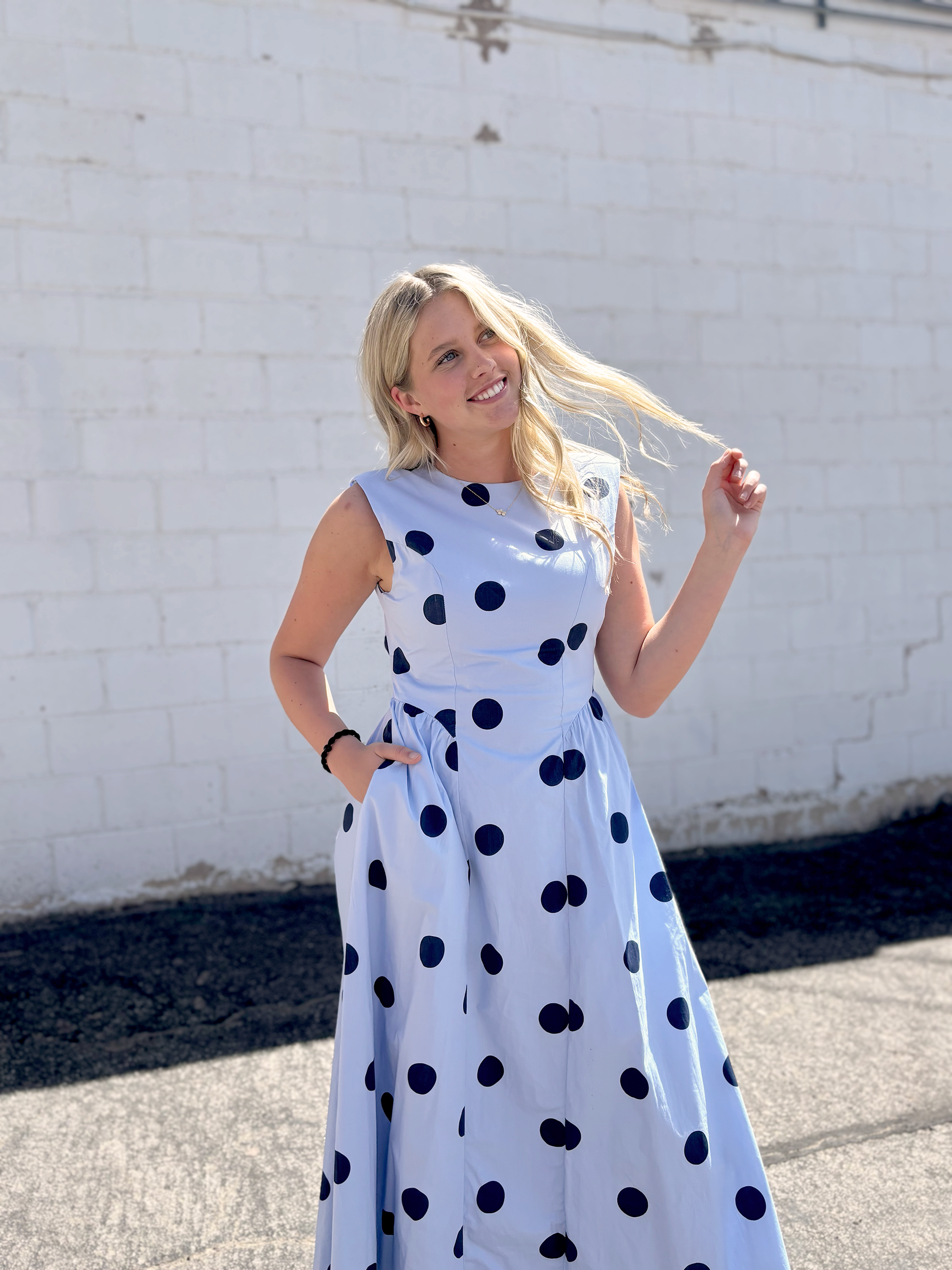 light blue sleeveless dress with navy polka dots and backless