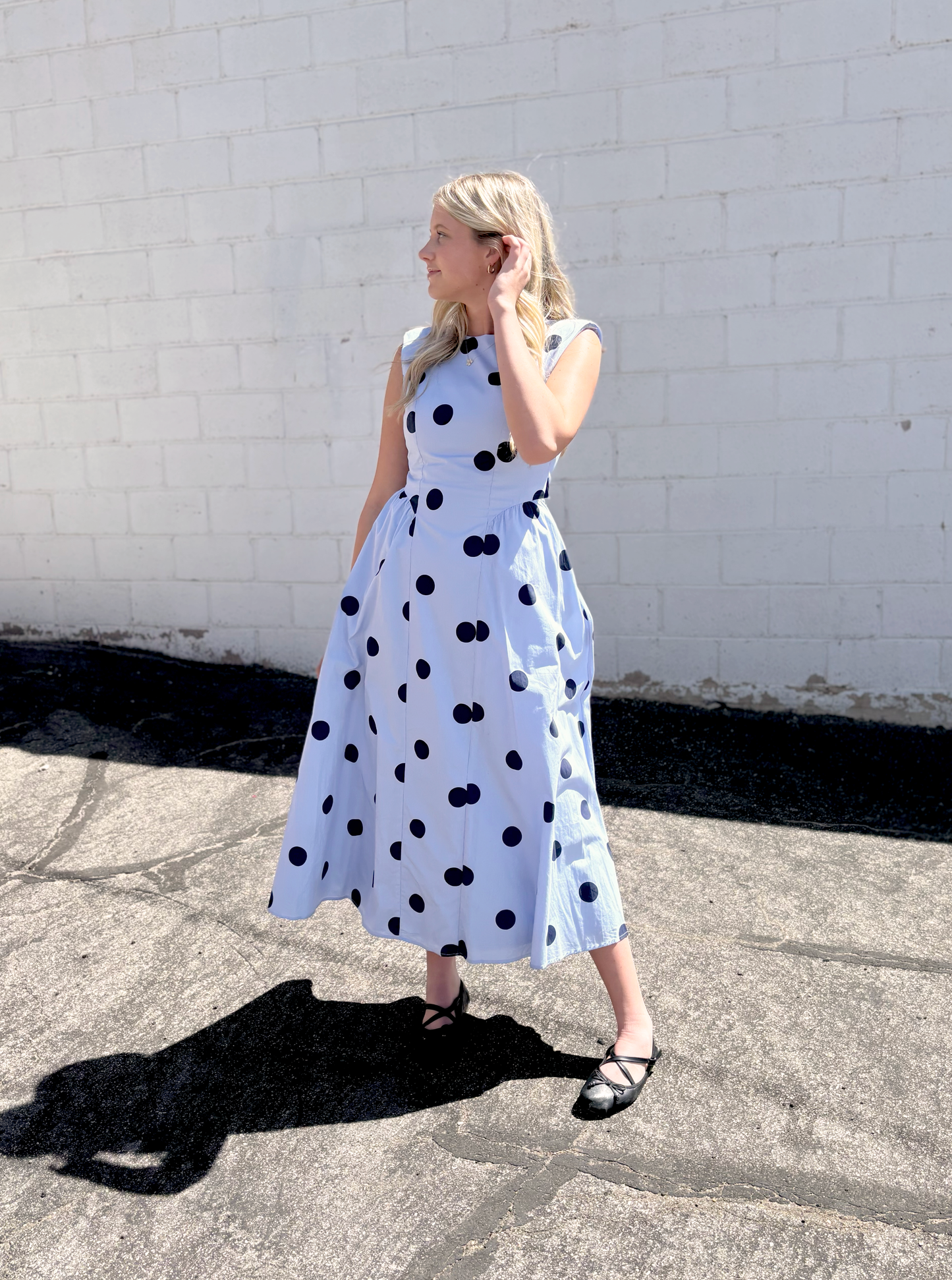 light blue sleeveless dress with navy polka dots and backless