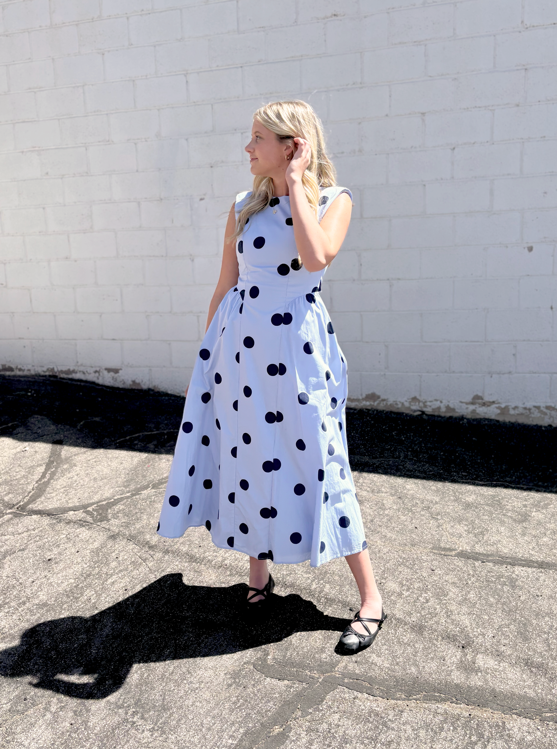 light blue sleeveless dress with navy polka dots and backless