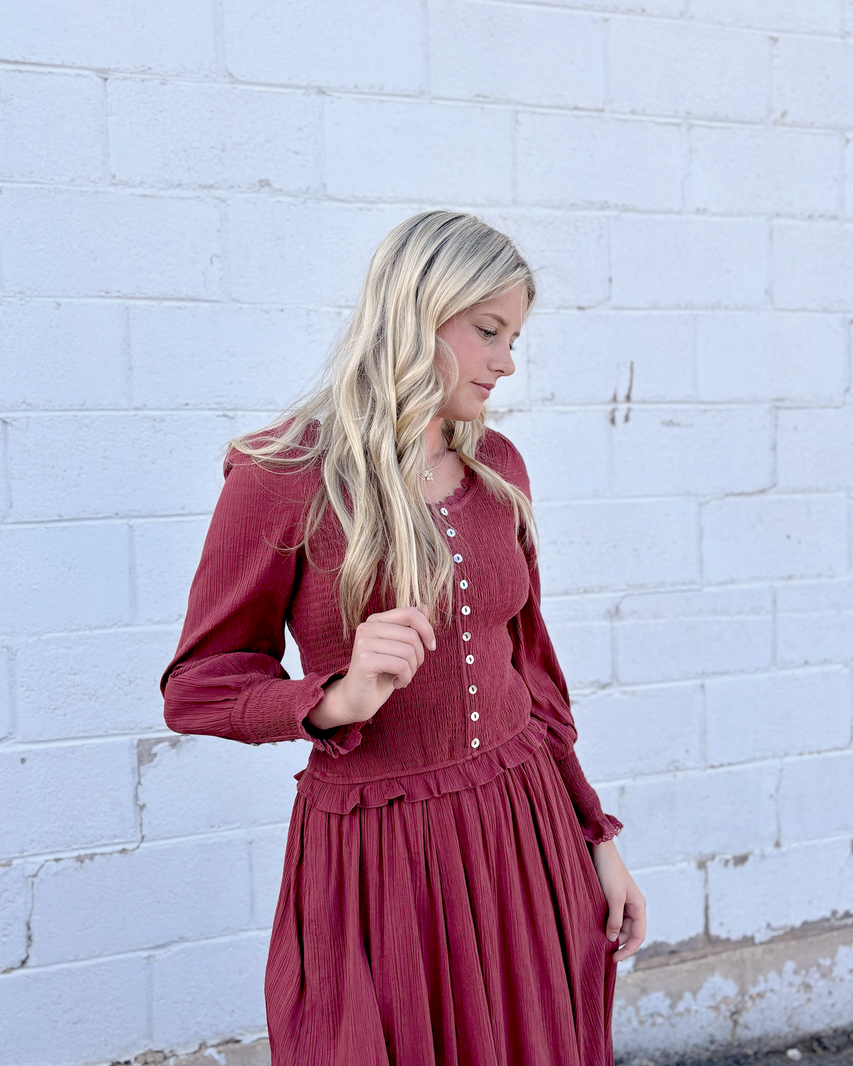 Rust colored dress with ruched bodice and long balloon sleeves and decorative buttons up the front and on the sleeve