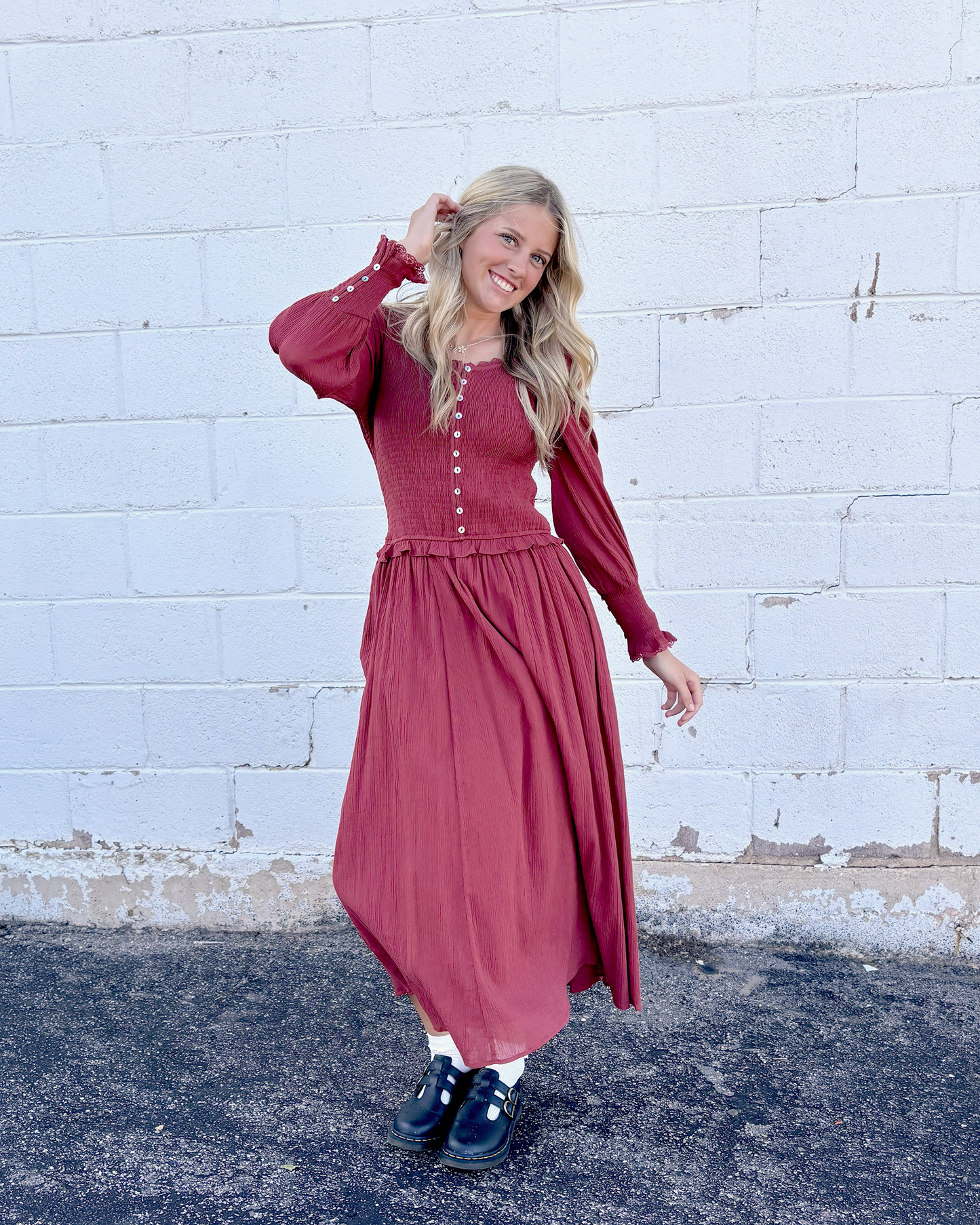 Rust colored dress with ruched bodice and long balloon sleeves and decorative buttons up the front and on the sleeve