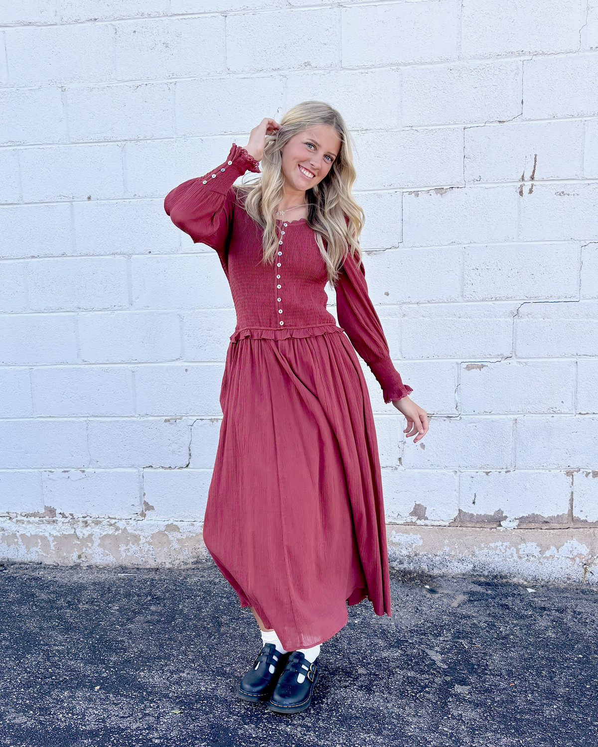 Rust colored dress with ruched bodice and long balloon sleeves and decorative buttons up the front and on the sleeve