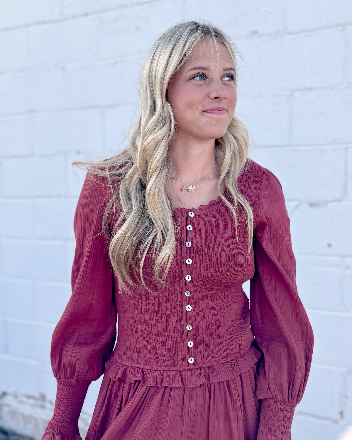 Rust colored dress with ruched bodice and long balloon sleeves and decorative buttons up the front and on the sleeve