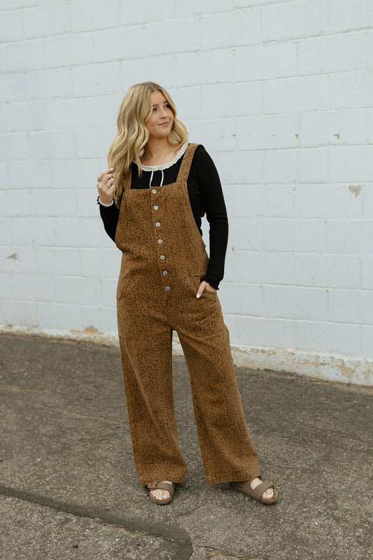 Overalls with a slight cheetah print and buttons up the front