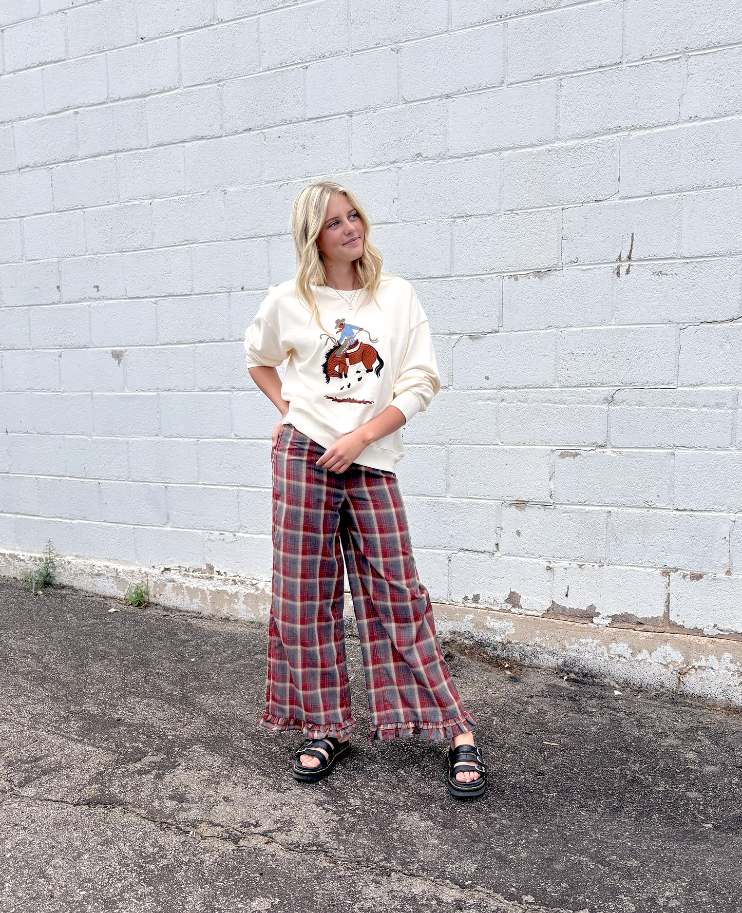 Cream colored sweater with a cowboy embroidered on the front
