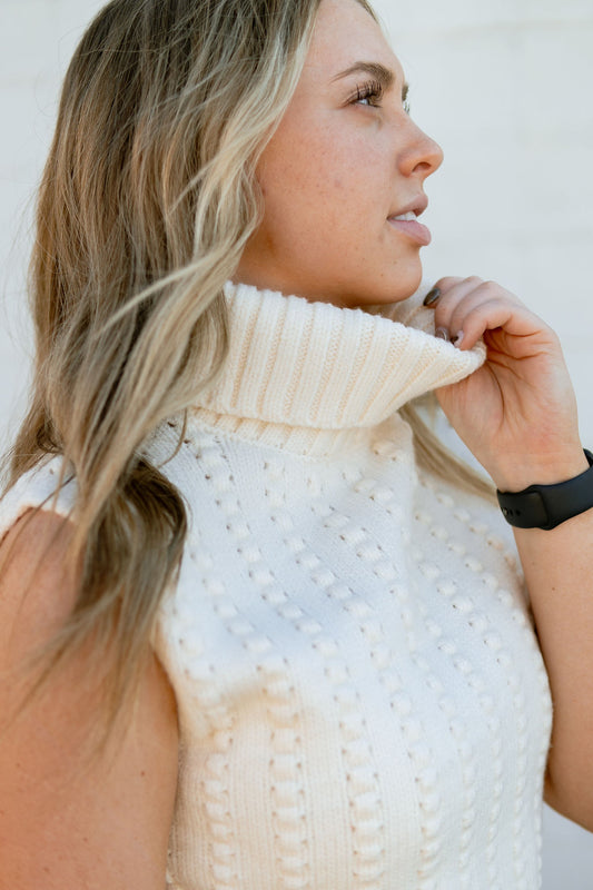 Cream sleeveless sweater with turtleneck