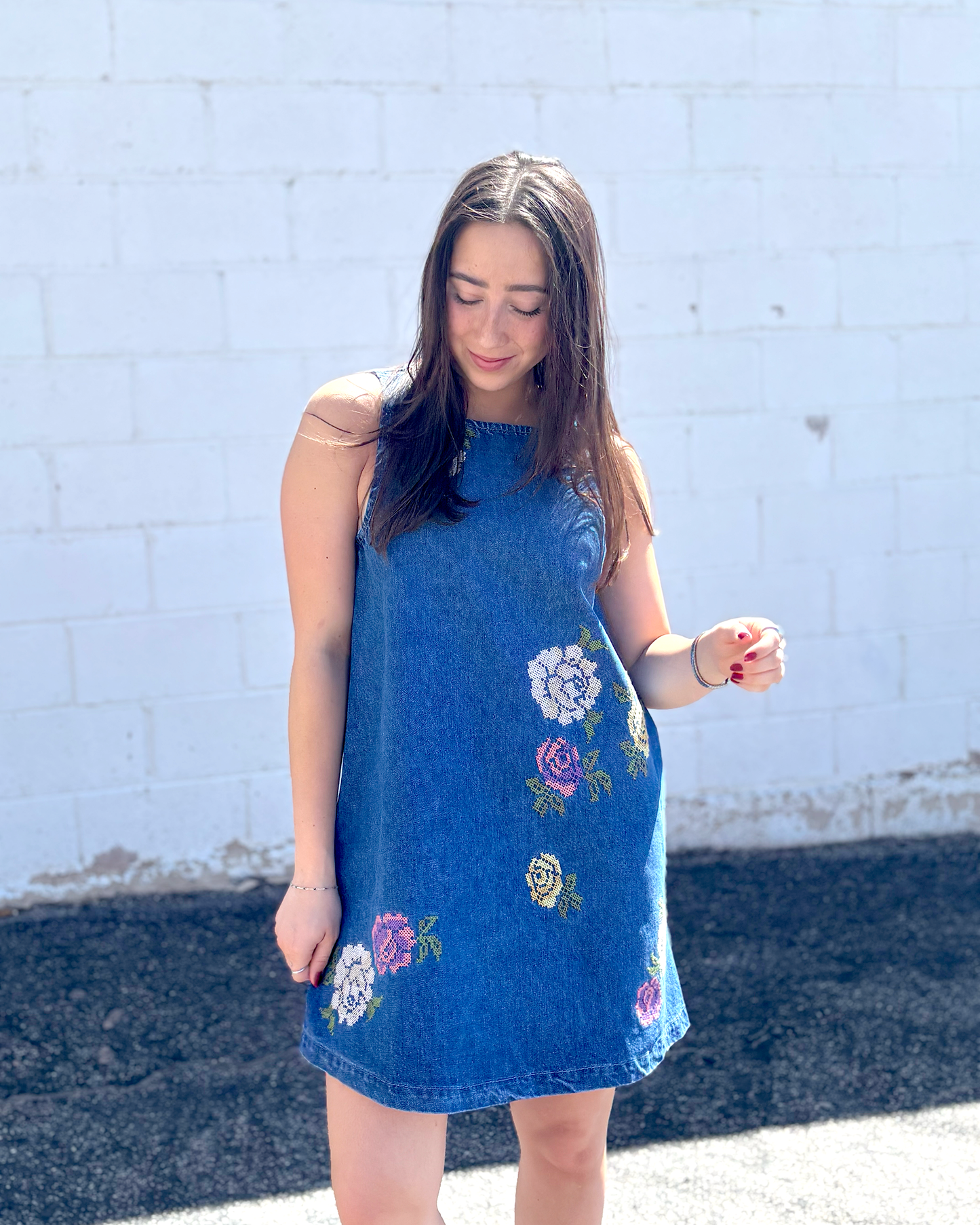 Cute short sleeveless denim dress with embroidered flowers on the front