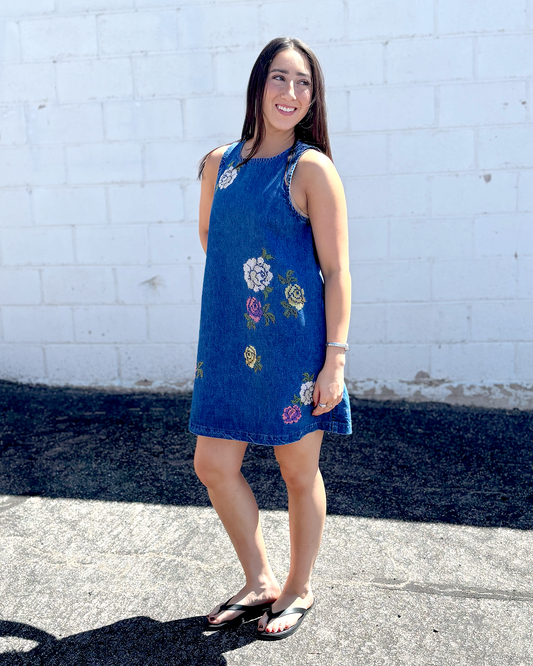 Cute short sleeveless denim dress with embroidered flowers on the front