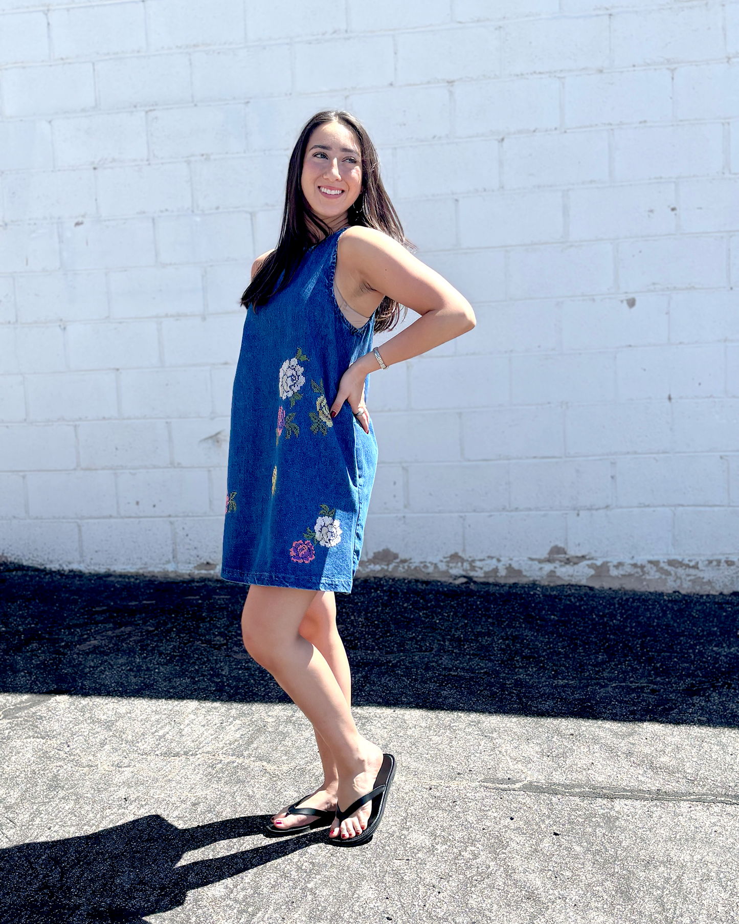 Cute short sleeveless denim dress with embroidered flowers on the front