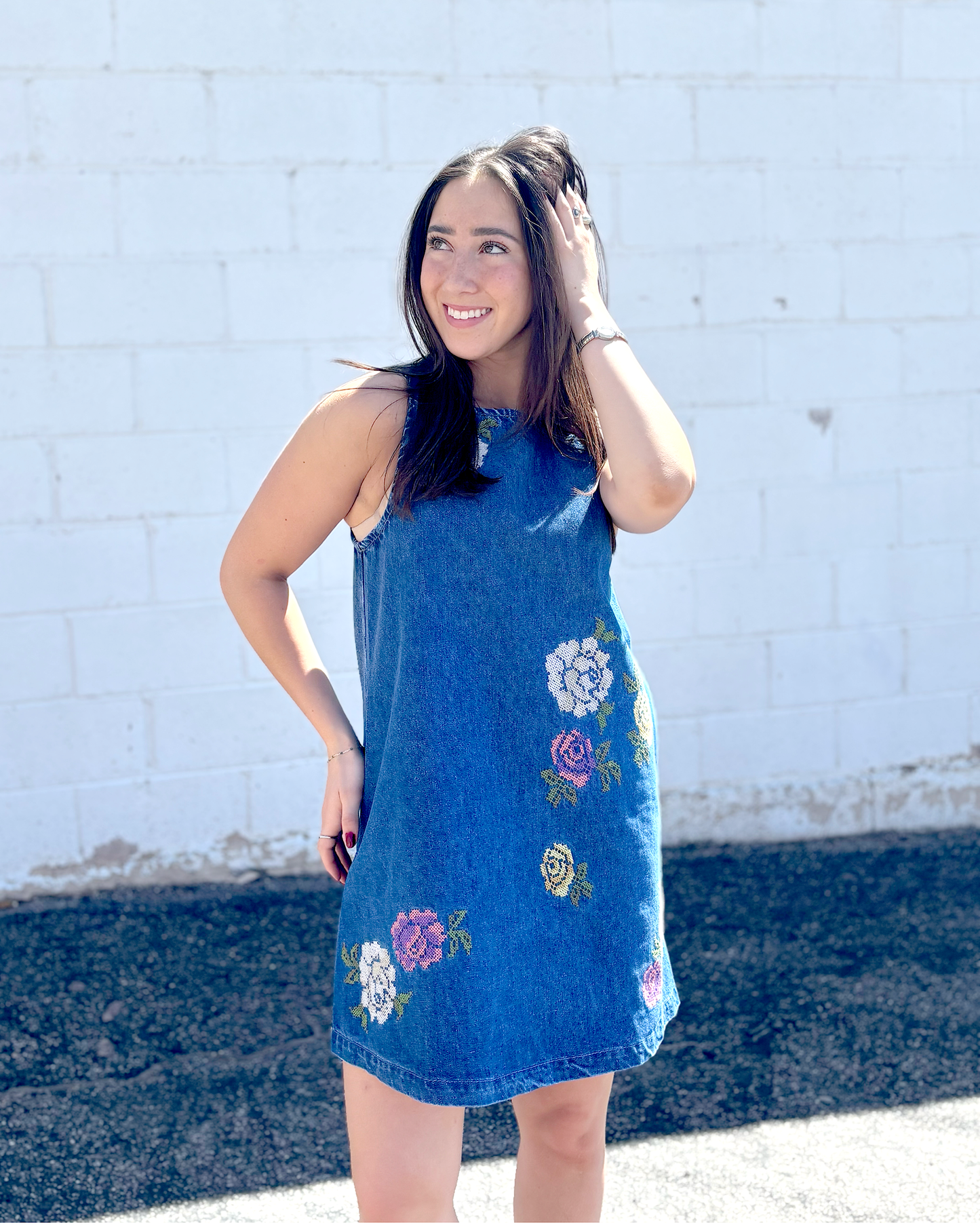 Cute short sleeveless denim dress with embroidered flowers on the front