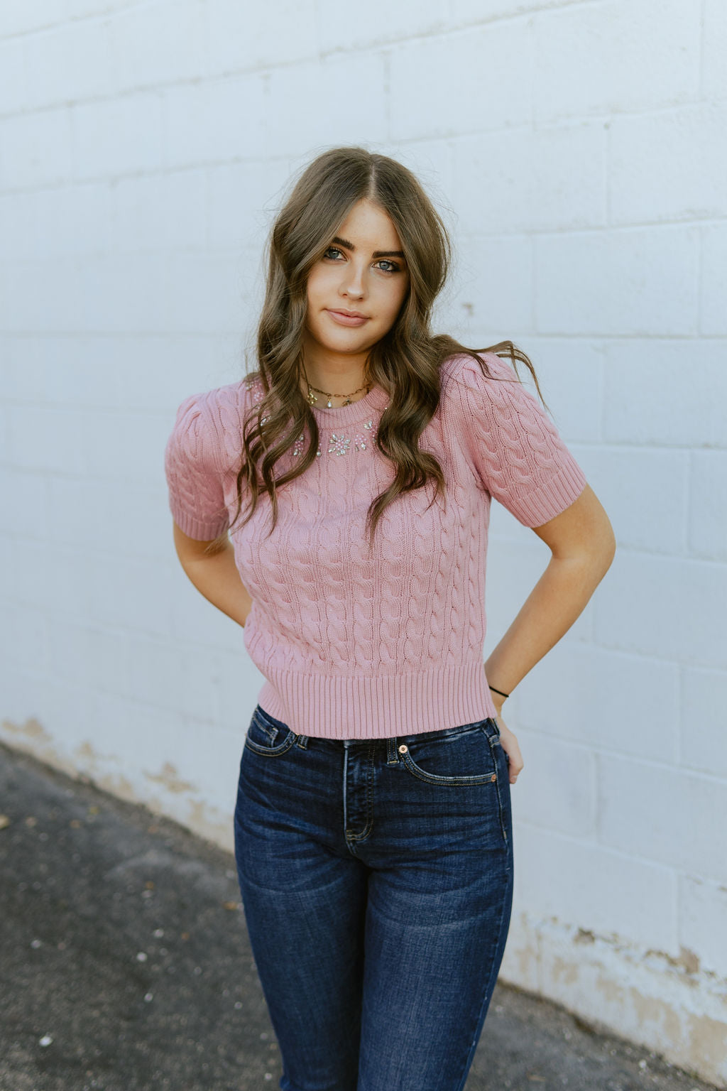 Pink cropped sweater with diamond details along the collar