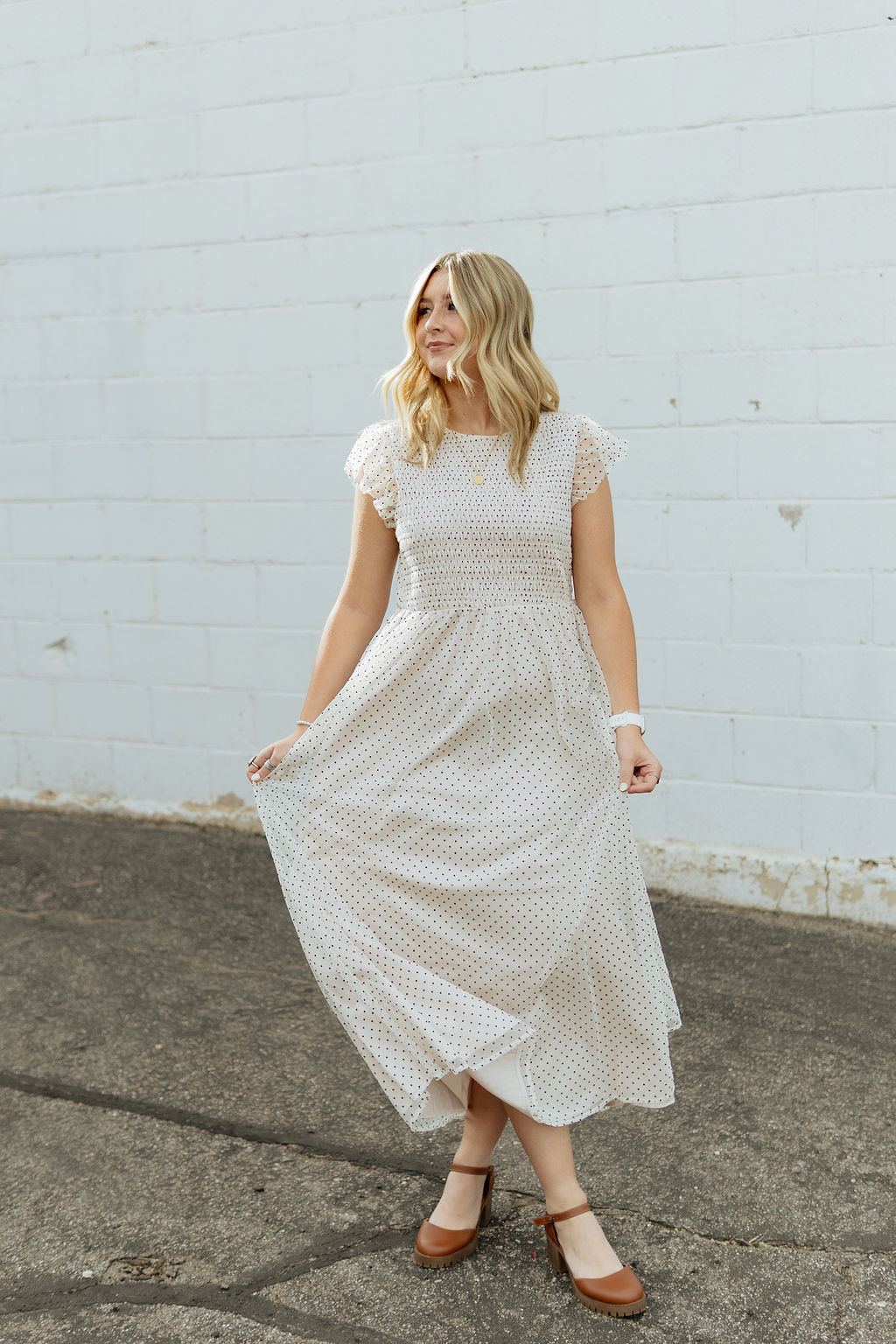 White dress with black polka dots and tulle details and flutter sleeves