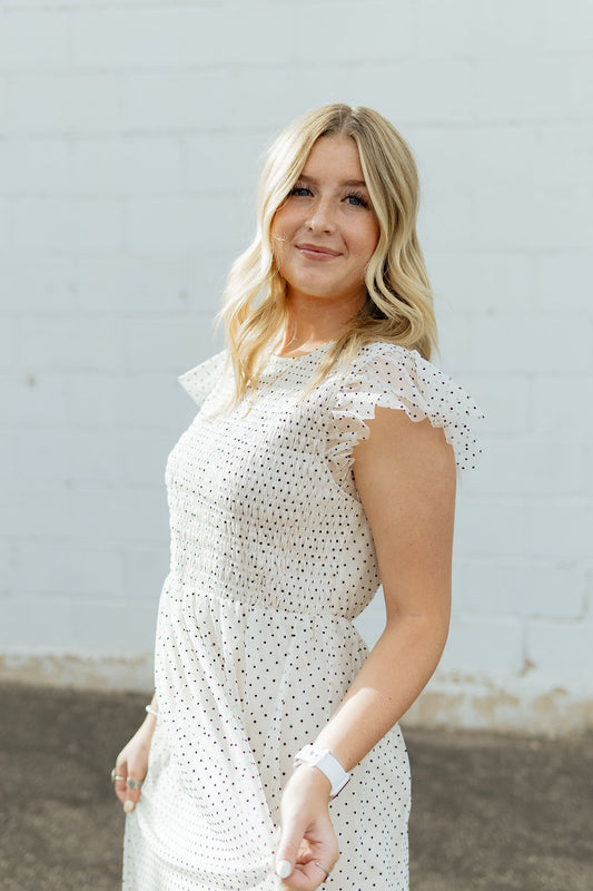 White dress with black polka dots and tulle details and flutter sleeves