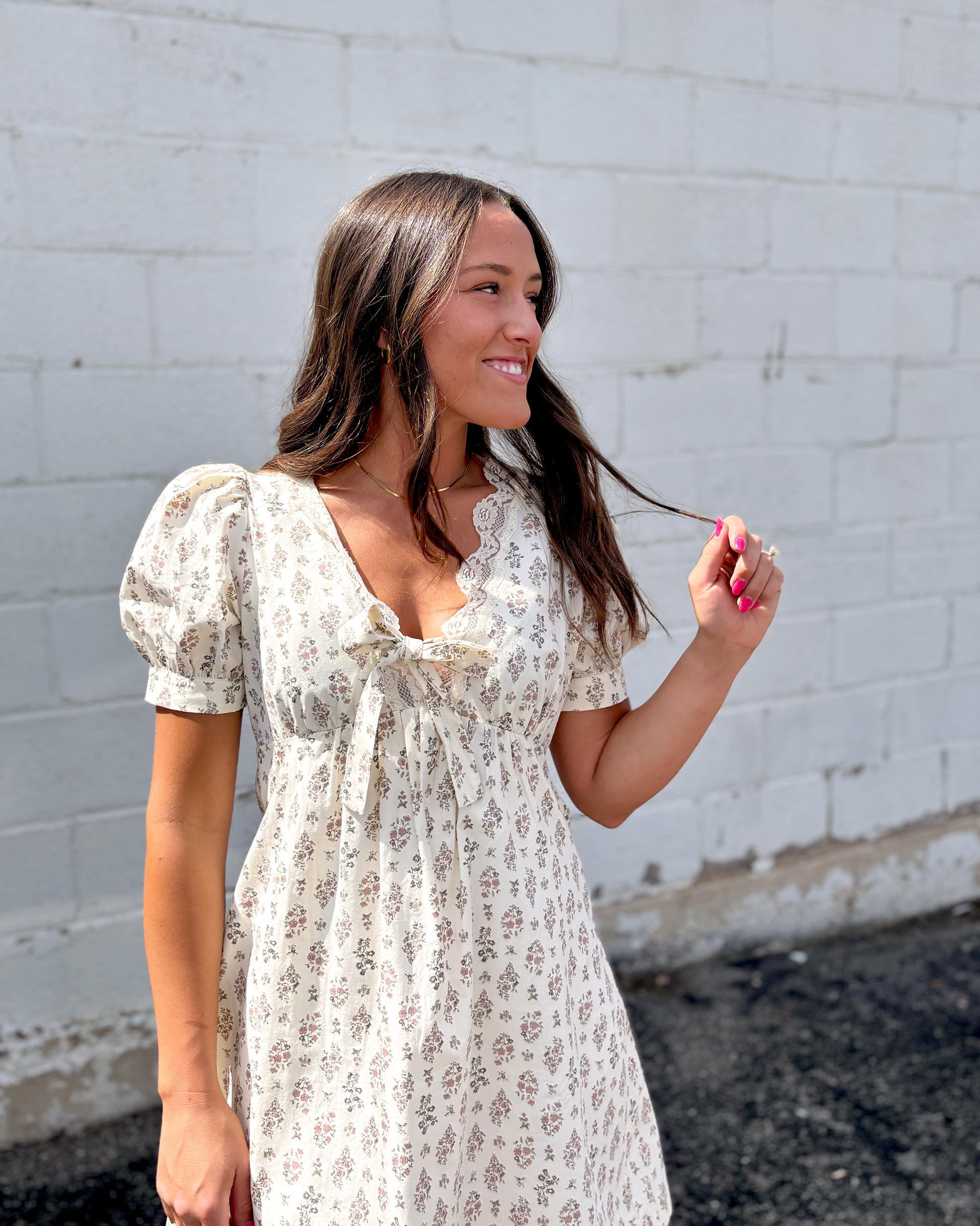 Ivory mini dress with puff sleeves and a v-neckline and a dark brown floral pattern