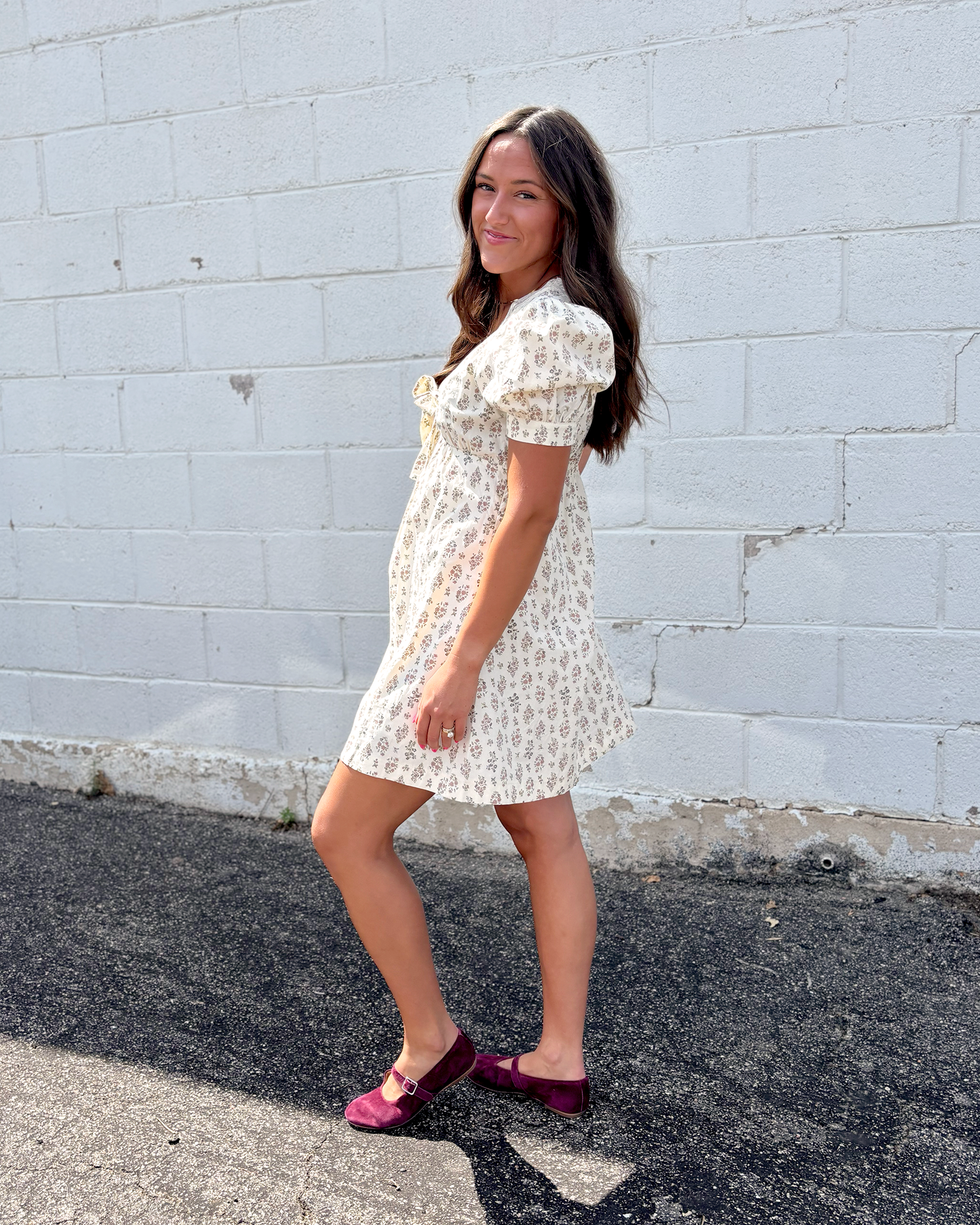 Ivory mini dress with puff sleeves and a v-neckline and a dark brown floral pattern