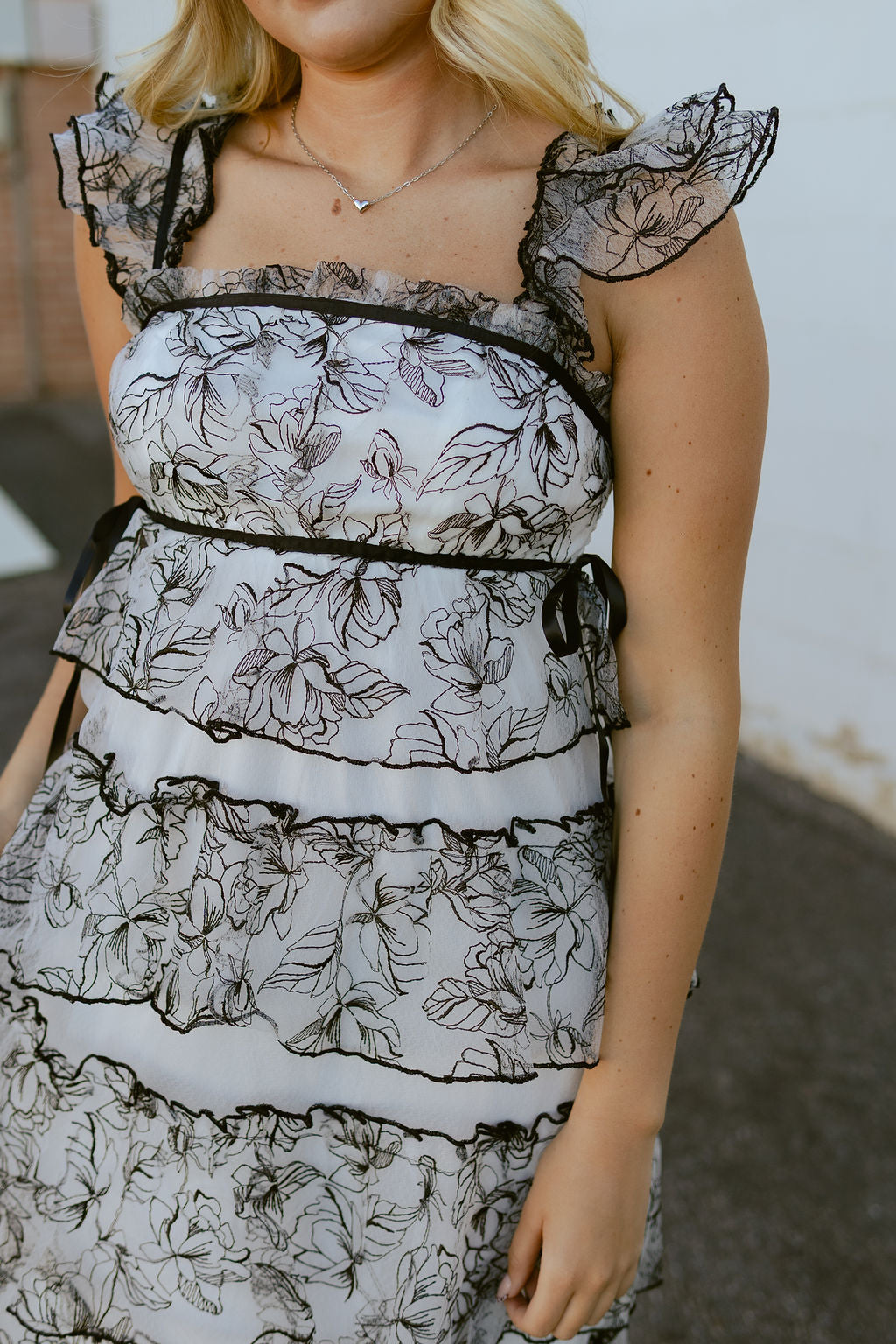 White dress with black lace over top