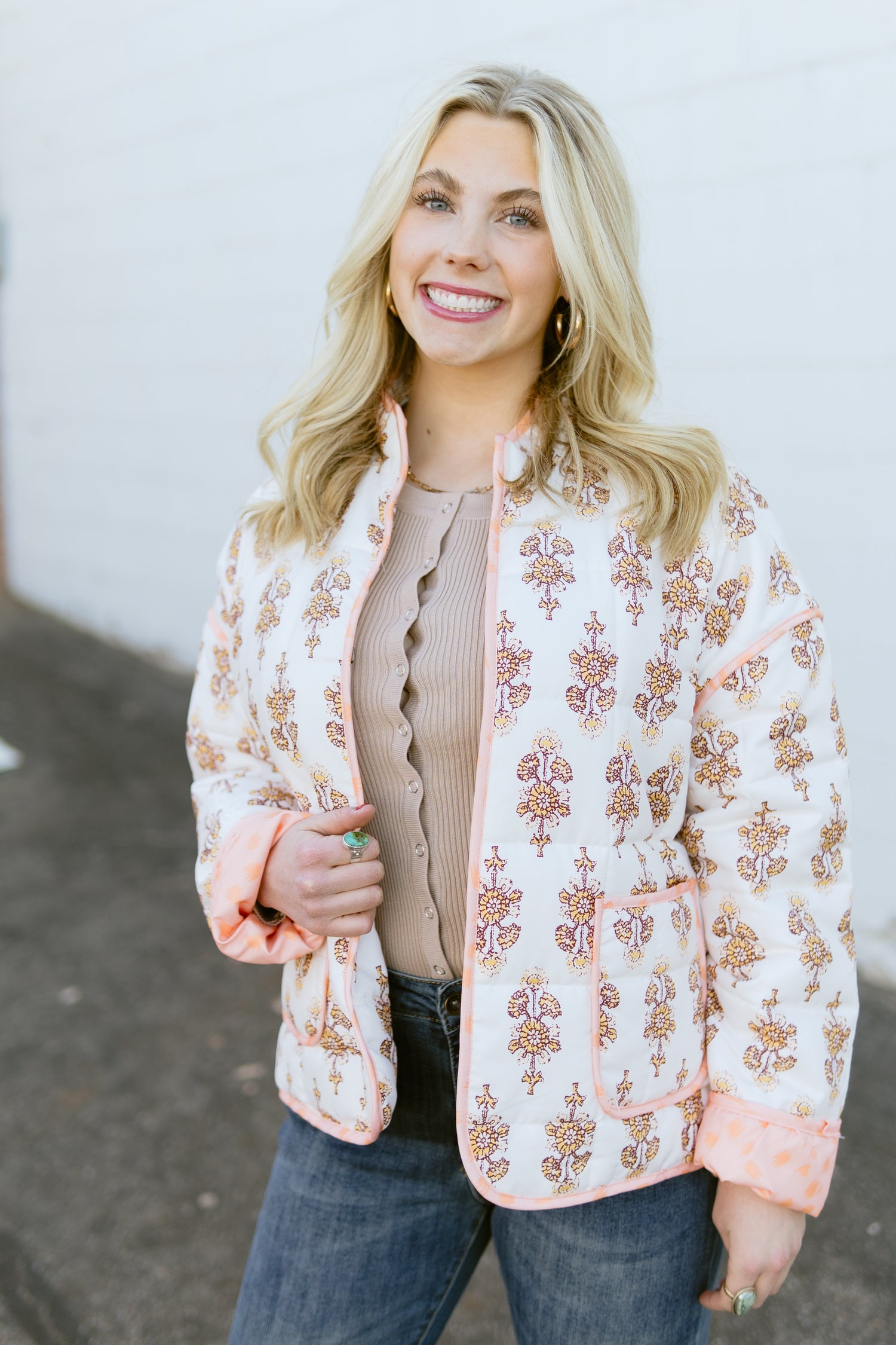 white quilted jacket with orange floral pattern and orange lining