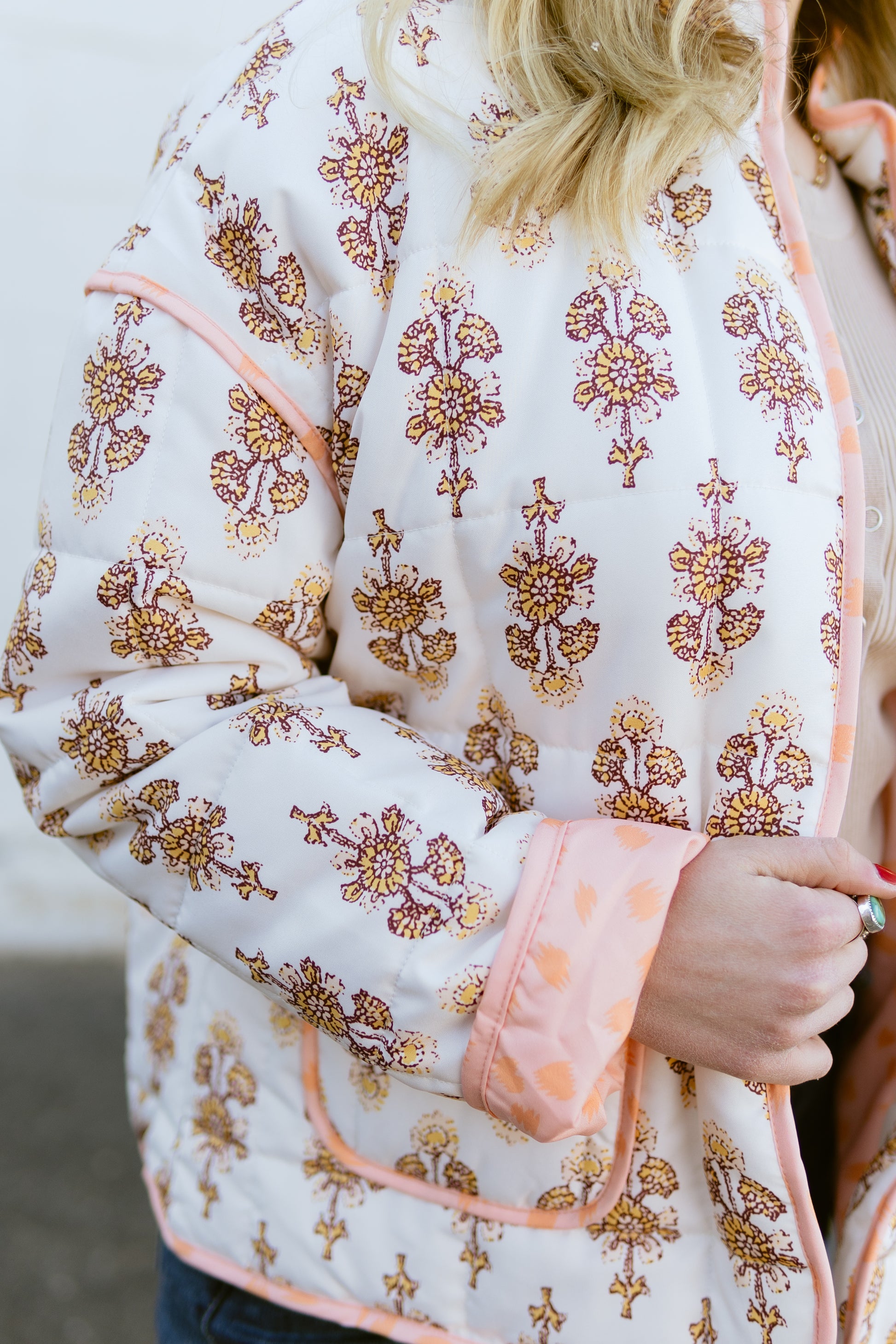 white quilted jacket with orange floral pattern and orange lining