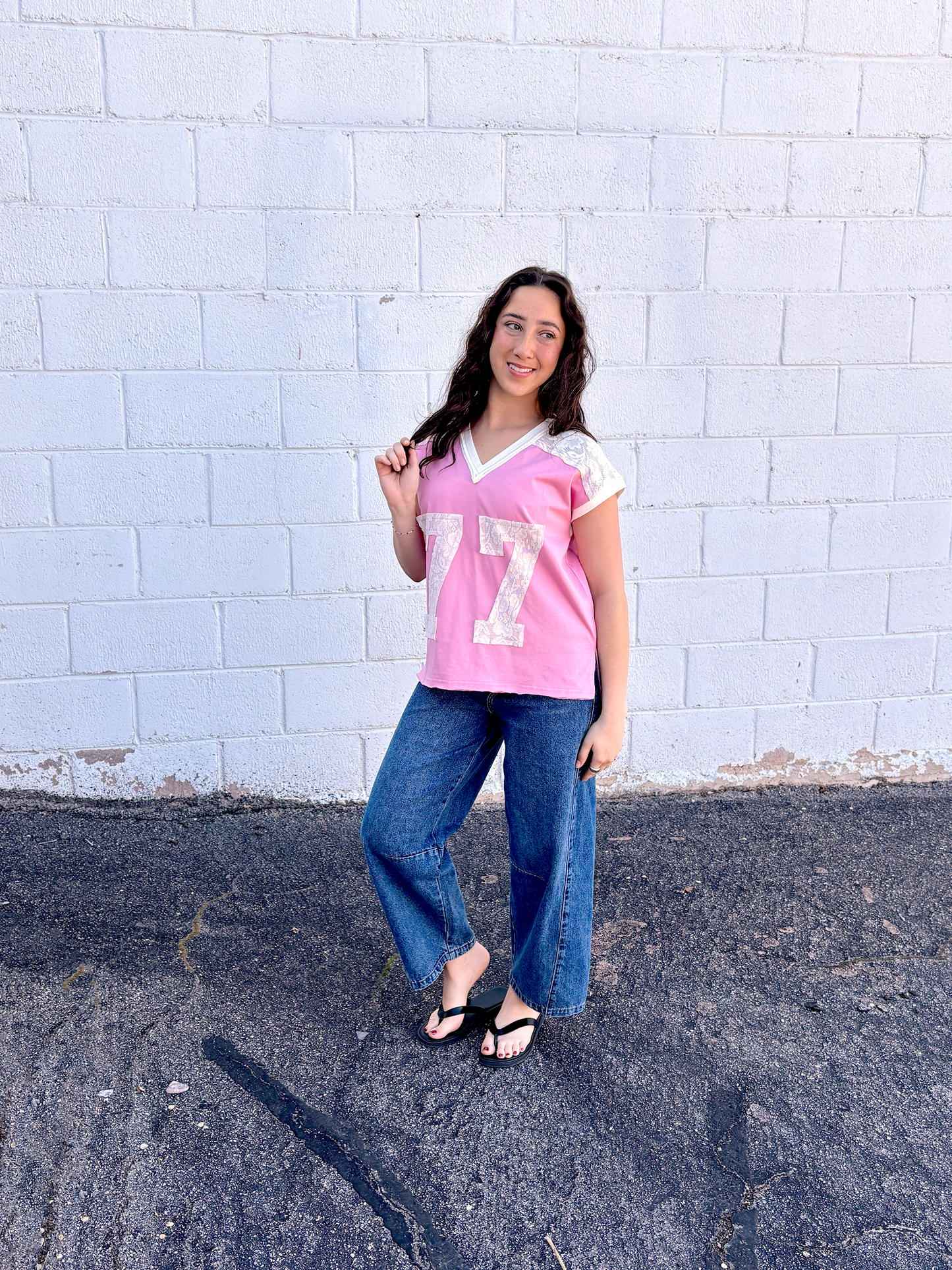 Cute pink tee shirt with lace along the shoulders and a lace 77 appliquéd on the front