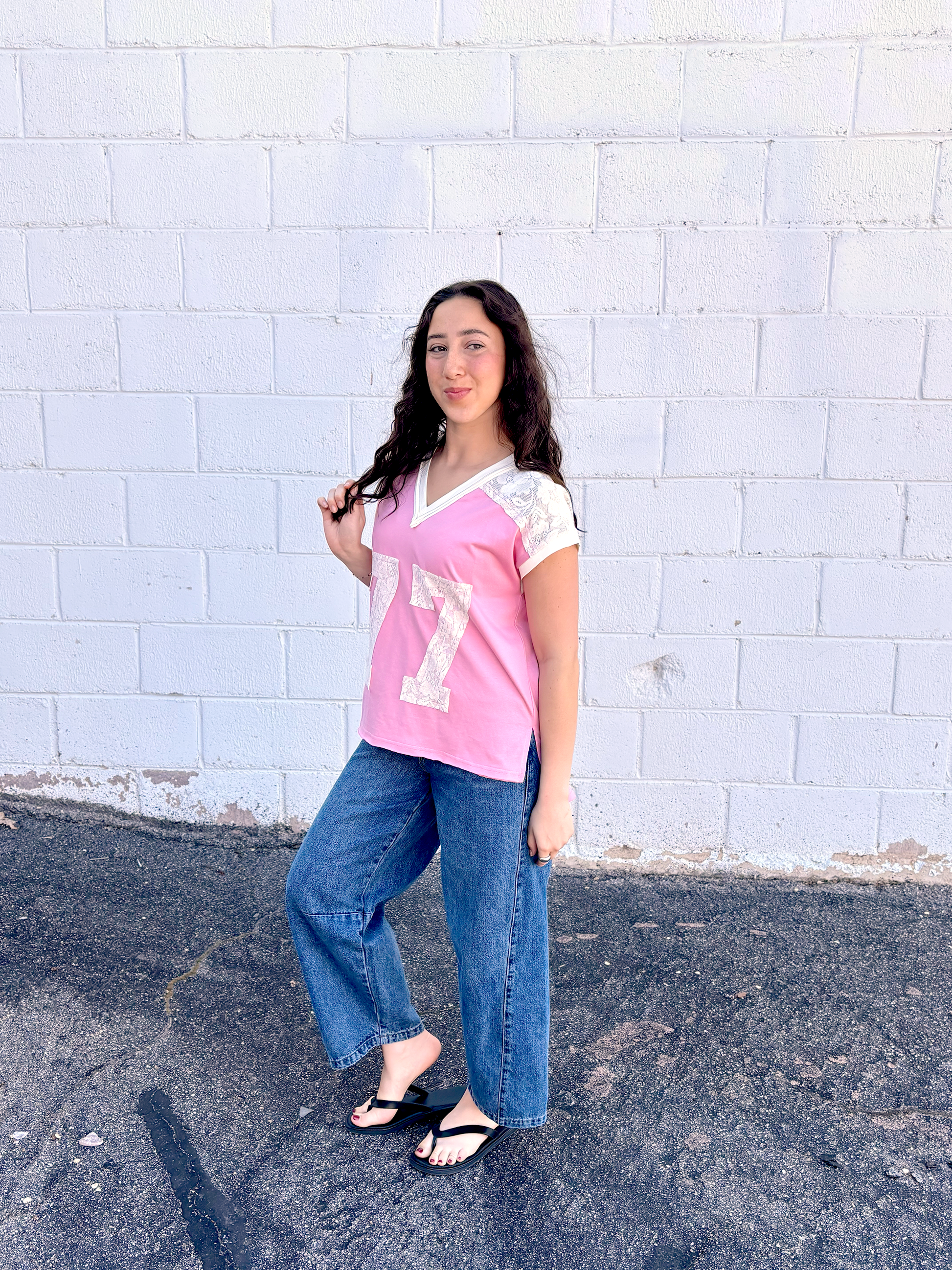Cute pink tee shirt with lace along the shoulders and a lace 77 appliquéd on the front