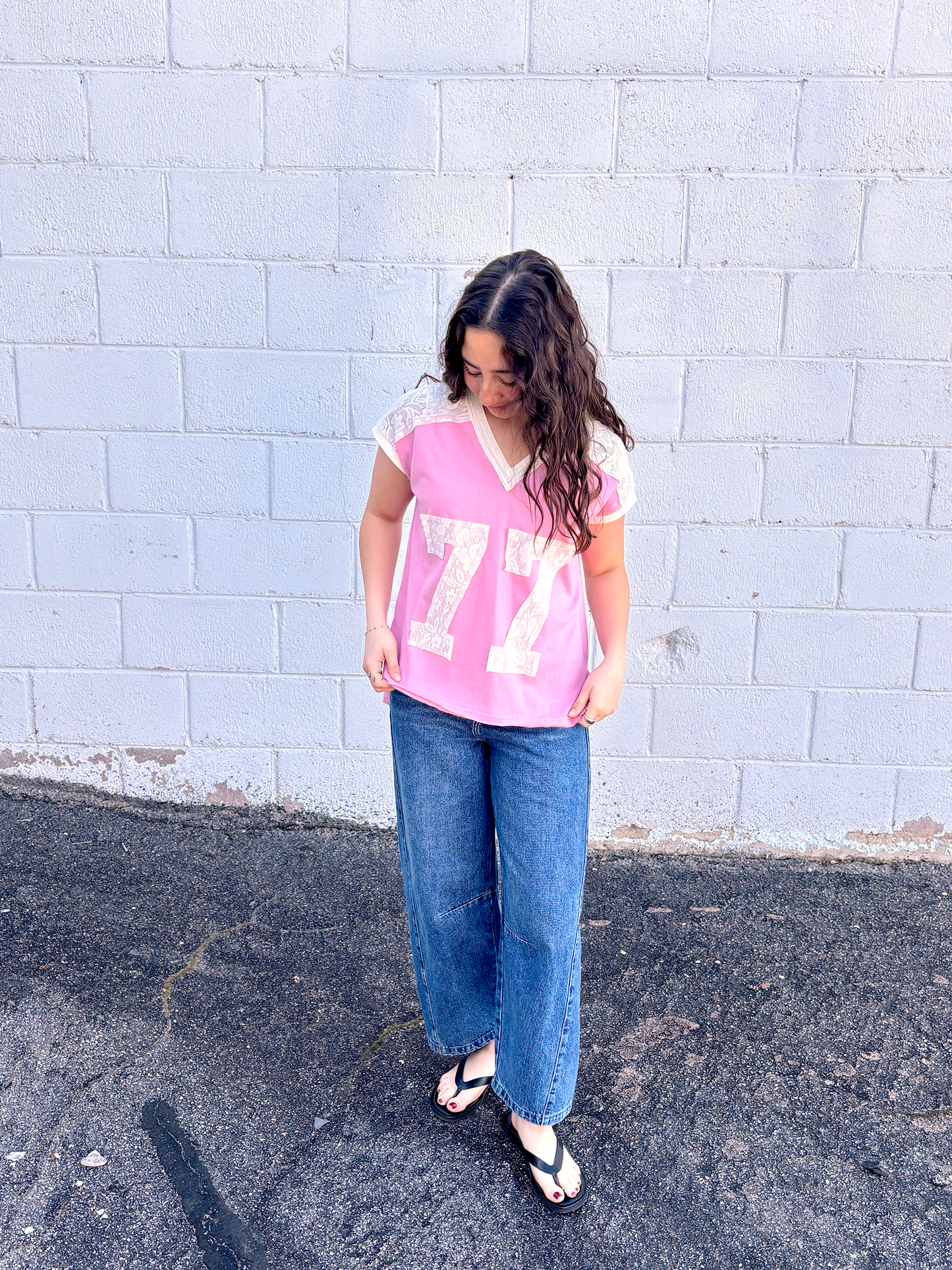 Cute pink tee shirt with lace along the shoulders and a lace 77 appliquéd on the front