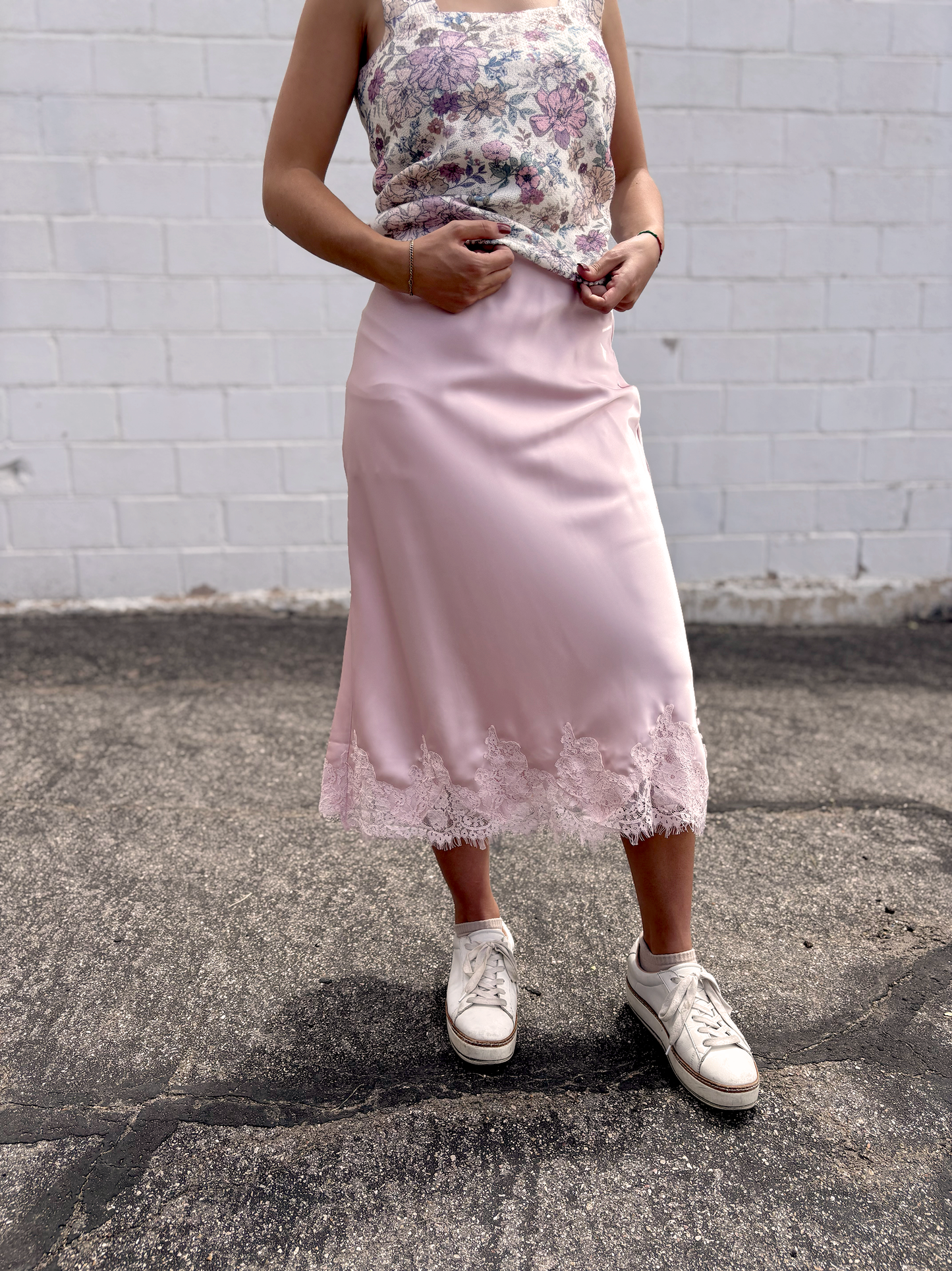 Pink satin skirt with lace trim along the bottom