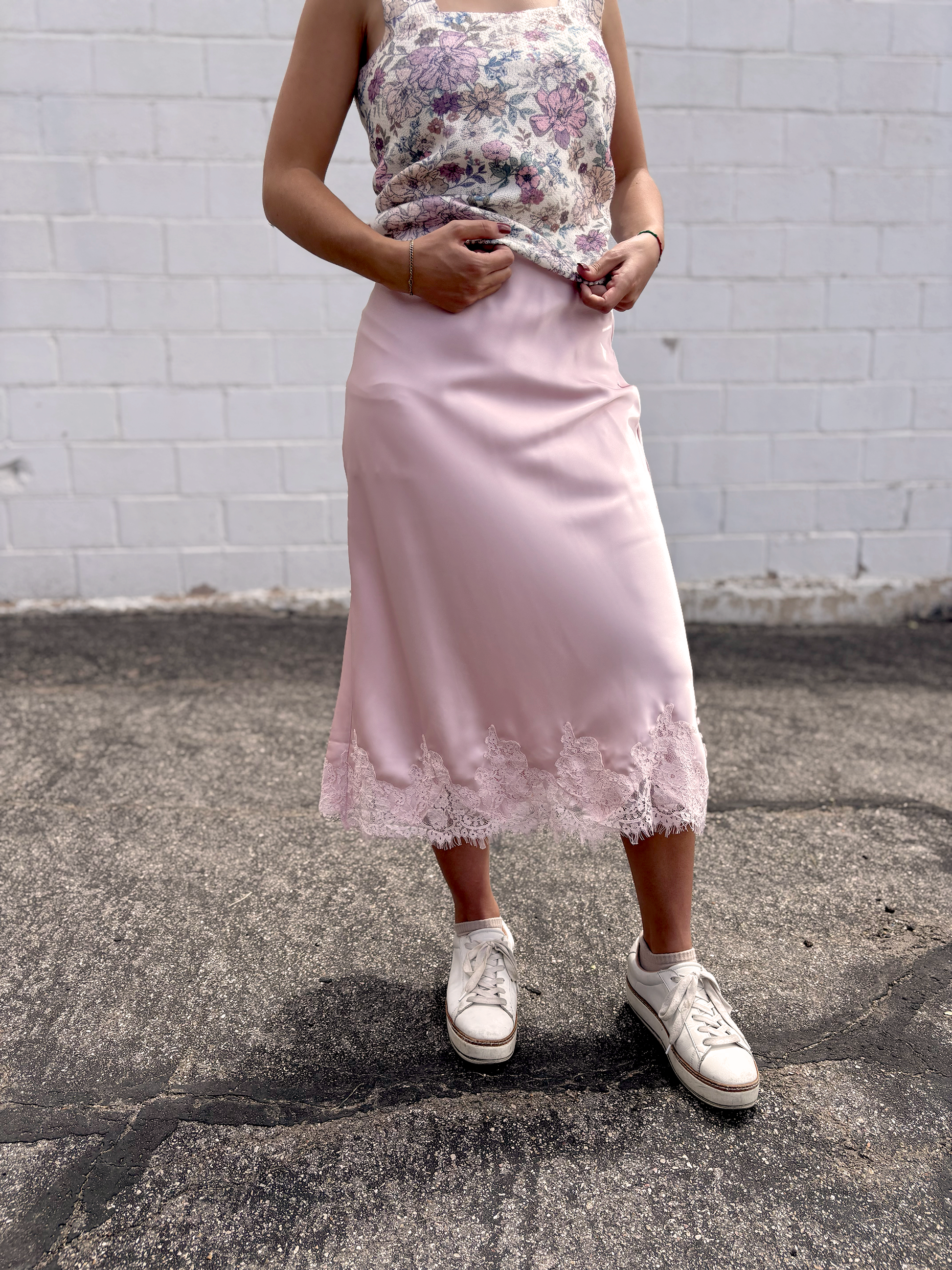 Pink satin skirt with lace trim along the bottom
