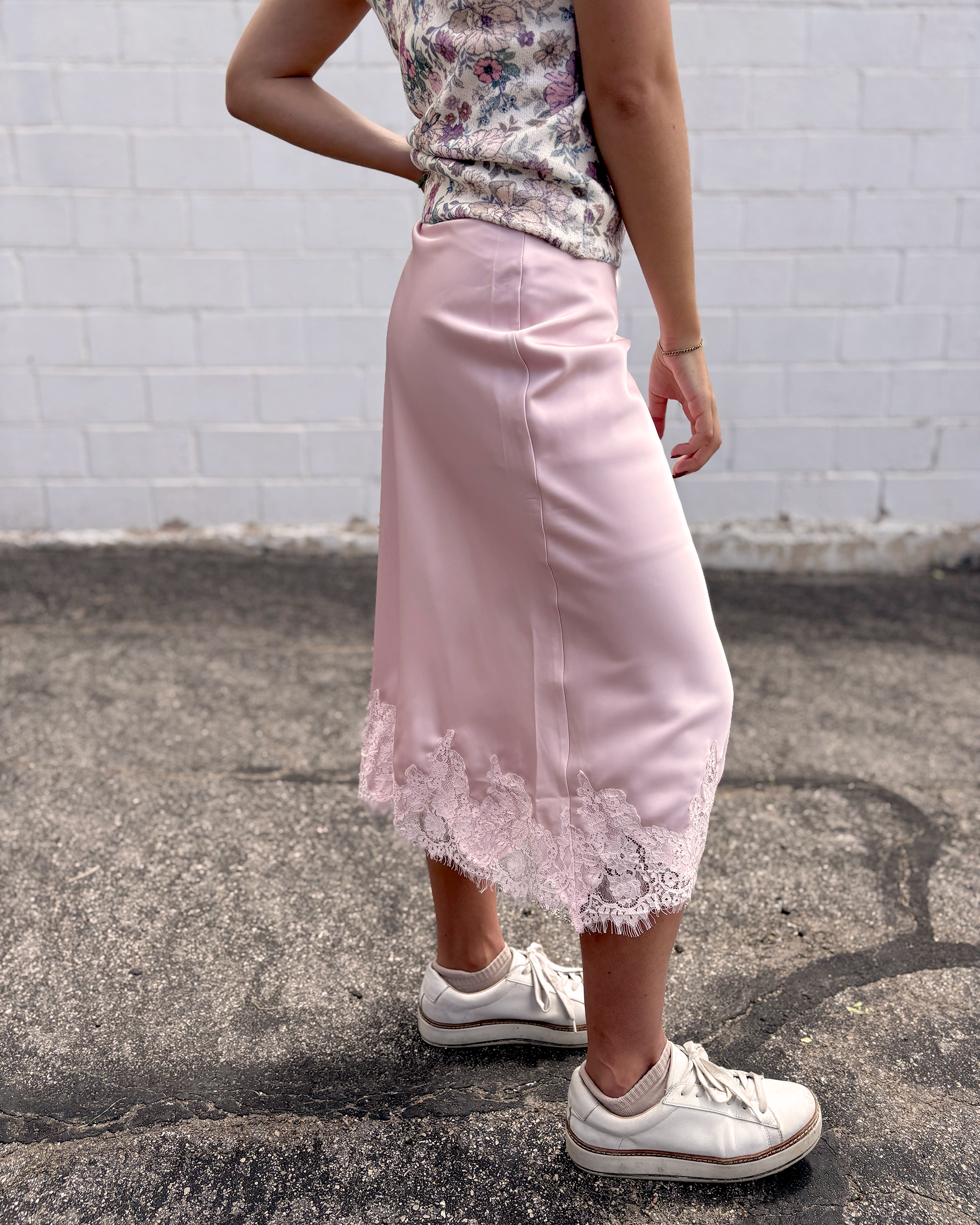 Pink satin skirt with lace trim along the bottom