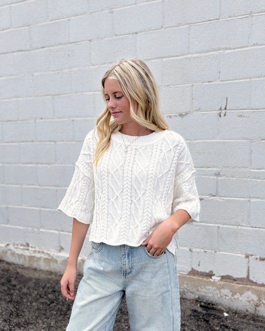 Cute white cropped sweater with short sleeves in a cable knit pattern