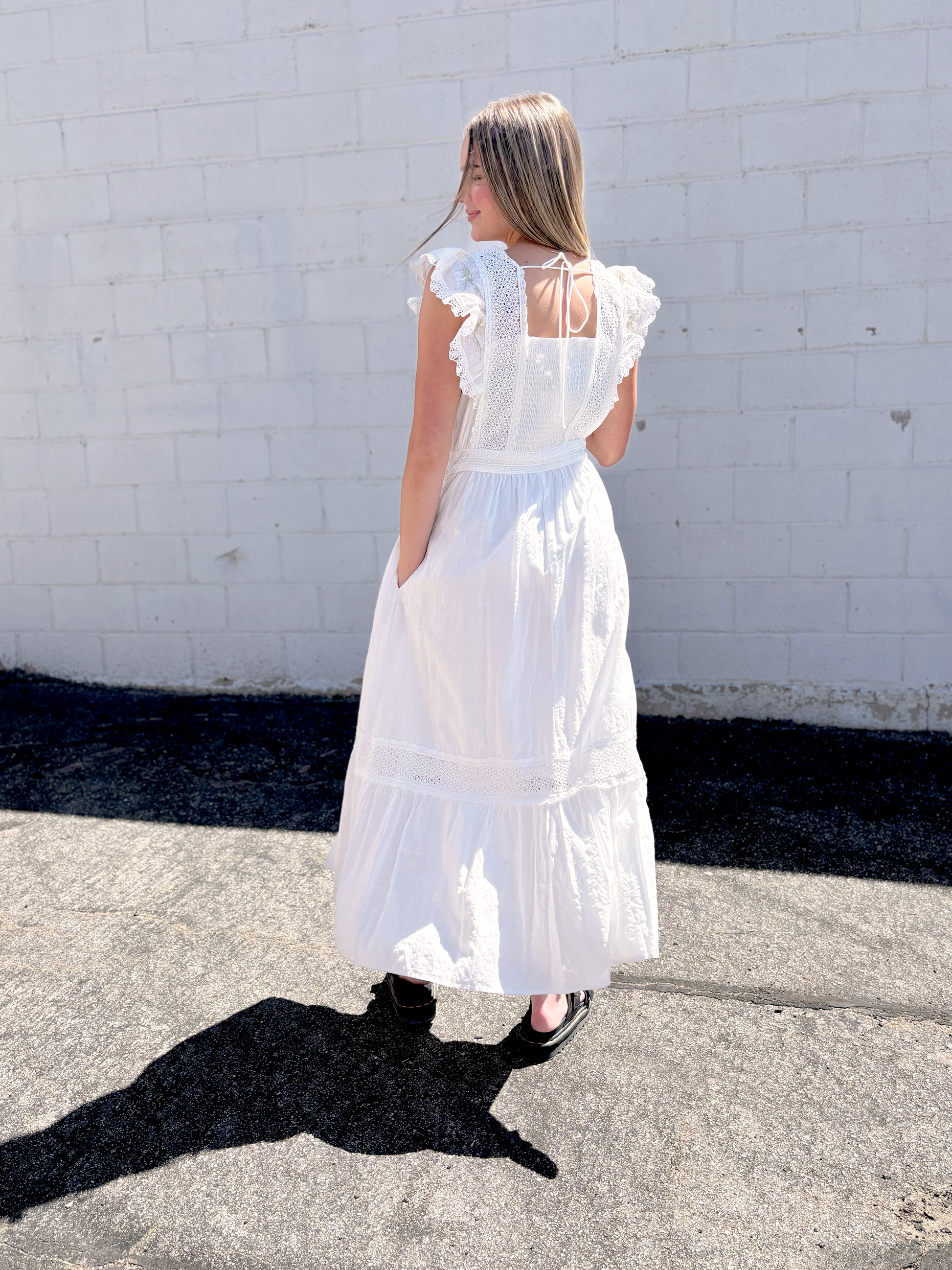 White dress with flutter sleeves and embroidered details
