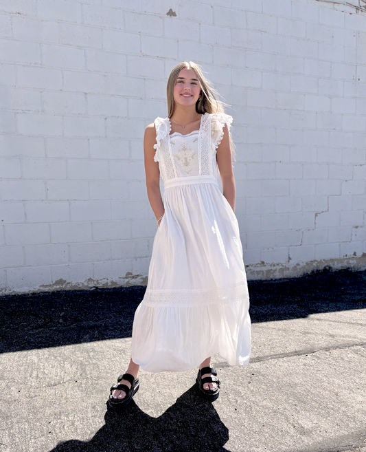 White dress with flutter sleeves and embroidered details