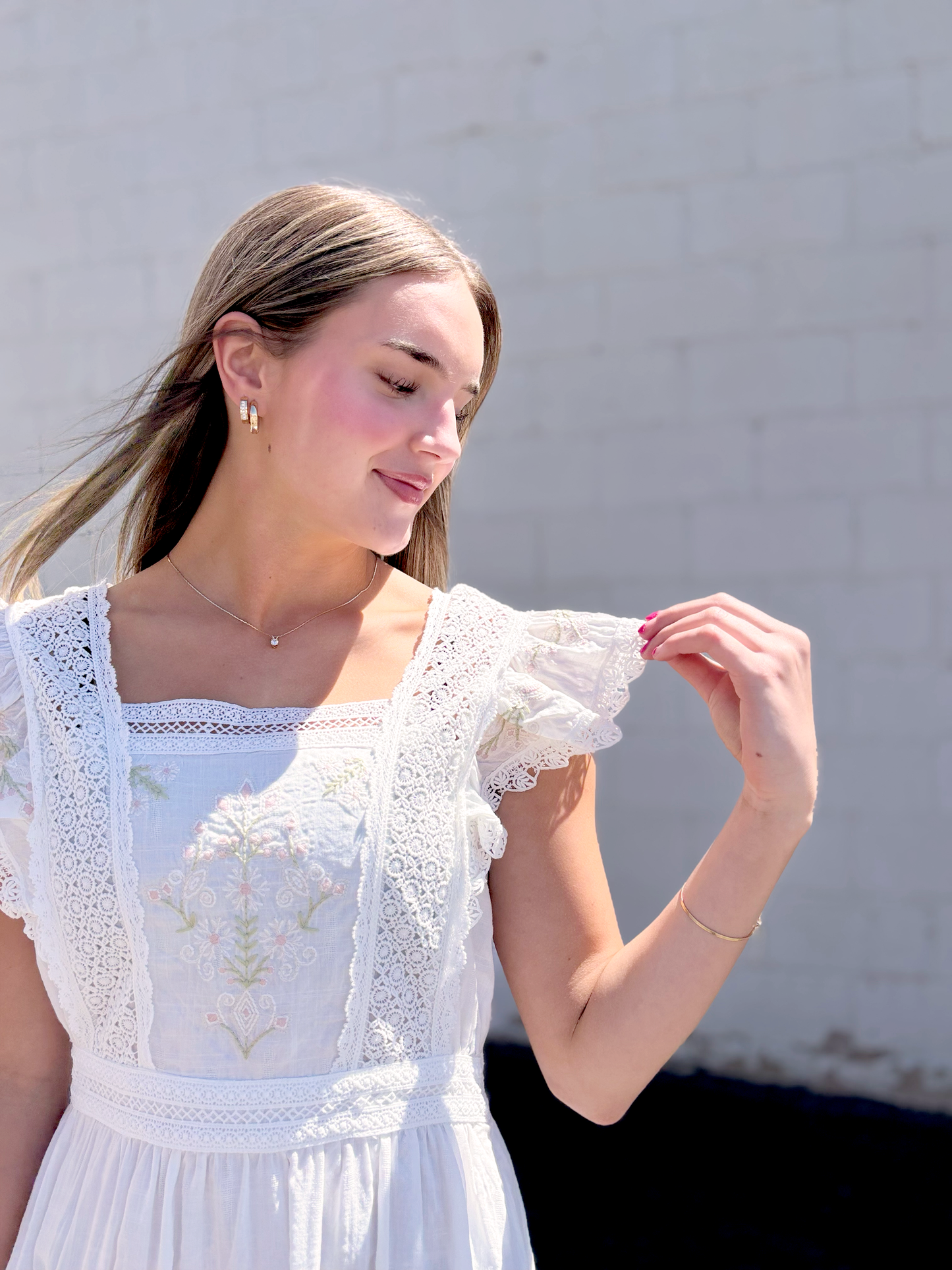 White dress with flutter sleeves and embroidered details